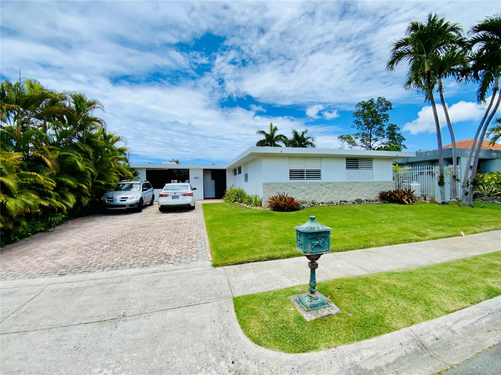 Welcome to a rare opportunity to own a property that offers both charm and potential in equal measure. Set on a generous 603 square meter lot, this residence also enjoys the exclusive benefit of an adjacent remanente land—not deeded, but freely used and appreciated by all surrounding homeowners. Once part of the train's right of way, this bonus green space offers added privacy, serenity, and space to enjoy.
Step into a home that holds true to its original layout and aesthetic, giving you the perfect canvas to personalize with your own updates and renovations.
Outside, enjoy sunny days around the pool, lounge on the open sun deck, or host gatherings on the spacious terrace. A full backup generator ensures year-round comfort and reliability.
Nestled in the heart of Guaynabo, the Torrimar community offers unmatched convenience and accessibility. This centrally located neighborhood is just minutes away from top-rated schools, grocery stores, shopping centers, and a wide range of commercial establishments. Residents enjoy the added benefit of being adjacent to the Torrimar train station, making commuting a breeze.
Right next door is the beloved Torrimar Sports Complex - a vibrant green space featuring extensive sports facilities, a fully equipped gym, and recreational areas for all ages.
Whether you're looking for a peaceful retreat or a place to create your dream home, this property offers an unbeatable combination of location, land, and potential. Make it yours today and bring your vision to life.