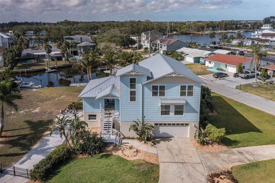 Elevated waterfront pool home, abundant dockage, *attached buildable waterfront lot*, one canal off the river!  This coastal-themed beauty with *elevator* has had a full remodel and addition done since 2020.  The elevated main living floor has a generous kitchen with large island, wall ovens, ice maker, smart hood with TV display, trash compactor, and counterspace for all your projects. The lower cabinets are outfitted with pull-outs for easy access. Adjacent great room with cathedral ceiling and floor to ceiling windows can be used for dining or gathering around the modern electric fireplace.  Conveniently located on the same floor are three bedrooms, two bathrooms, and the dedicated laundry room.  The primary retreat has water views and access to your outside deck. There will be no fighting for storage in the oversized primary closet, with built-in organizers including a crafting desk and sewing cabinet, and the primary bathroom has still more storage for two, large shower and clawfoot tub, plus water closet still provides privacy. Upstairs loft area has another dedicated seating area, a movie-watching space with ceiling projector and surround audio, and private office area with Gulf views, while the glass railings allow natural light access all of the space.
With upgraded vinyl impact windows and sliders, watch manatees and dolphins play behind your home while enjoying the noise and energy benefits of the insulated glass.  Outside there are two 10,000lb boat lifts, jet ski lift, a floating dock, and davits for your fleet of red-fish catching boats.  The pool and deck were also remodeled, and you'll enjoy relaxing on the built-in sun shelf or entertaining under the covered patio, which includes a weather enclosure for your outdoor TV.   A dedicated irrigation well means the landscaping is easy to maintain without a separate water bill!
Not included in the listing living sqft is your downstairs GAME ROOM/guest room, with full updated bathroom inc walk-in shower for easy washing after boating or pool days, and concrete wall panels up to 6' so you don't have to worry about drywall below the main living floors. The garage has room for 3+ cars, work bench, plus large storage area, all the electrical outlets a hobbyist could need, and even a sliding hoist.  No need to pay for trailer or boat storage, there's room in your empty lot to park your toys on the gravel side drive.
The HVAC, metal roof, impact windows/sliders, docks, lifts, SEAWALL, pool/deck surfacing, landscaping have all been redone since 2020.  Low flood insurance currently at $1800/yr, with all your primary living space is on the elevated floors!  
Just a short boat ride from home will have you to the island of Anclote SP for beautiful uncrowded beaches or amazing flats fishing at Werner-Boyce SP. The City of Port Richey is a golf-cart permitted city and just a short cart ride from shopping, waterfront dining, and three parks with playgrounds, kayak launches, and fishing. The City also has its own police/fire depart, and city council for that small town feel but close to all big city amenities. Downtown NPR has many eateries and outdoor events just down Grand Blvd. When you need big city,  Tampa airport/downtown is direct via Ridge Road Extension to the Veterans, where Moffitt Cancer Center is currently building their new medical campus. Don't miss all of the outdoor adventures this property has to offer while enjoying living above the floodplain. 3D Tour in link