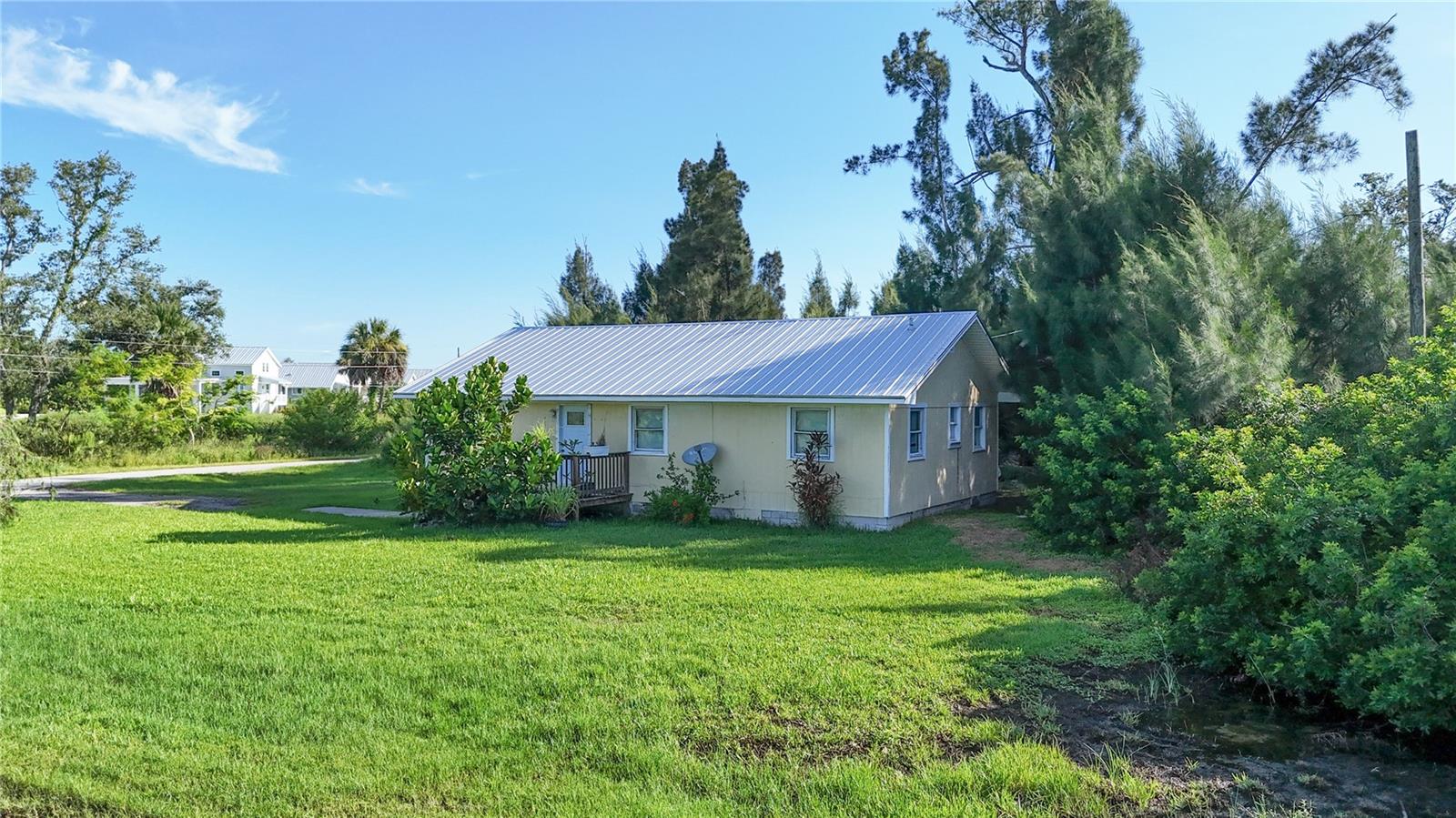 Investor's Dream ** CASH ONLY ** This 3-bedroom, 2-bathroom home is the perfect fixer-upper with endless potential. Featuring a well-designed layout and solid bones, this property is ready for your vision and updates. This home features a 2yr OLD METAL ROOF, UPDATED ELECTRIC PANEL, CITY WATER and is located on an CORNER LOT in a desirable area of Port Charlotte! With a little TLC you can make this home shine again! Enjoy the open living and dining spaces for everyday enjoyment and entertaining or the spacious 3 bedrooms for privacy and convenience. The large UPDATED KITCHEN offers a closet pantry, several cabinets and an abundance of counter space along with all the appliances you see! The kitchen sink has a window and hanging light that overlook your serene backyard view. Open the sliding glass doors from the dining room and step outside to a private backyard oasis with lush wooded view, perfect for relaxing or entertaining. The spacious, open deck overlooks mature trees, offering a peaceful retreat where you can enjoy your morning coffee or unwind in the evenings surrounded by nature. With no neighbors directly behind, you’ll appreciate the privacy and quiet this backyard provides year-round. The driveway offers plenty of room for parking multiple vehicles. Location is the true highlight, with the Gulf of Mexico's pristine beaches just a short drive away. Convenient shopping is nearby at Gulf Cove Publix Super Market, and Randy Spence Park (just a 2 minute walk to it!) offers a peaceful green space for outdoor enjoyment including playground, walking trails and outdoor basketball courts. Baseball enthusiasts will appreciate being minutes from Charlotte Sports Park, perfect for catching spring training games. Whether you're looking to renovate and resell or customize your next home with some sweat equity, this is a rare opportunity in a growing area. Priced to sell – bring your tools and imagination! At this price, it won't last long!