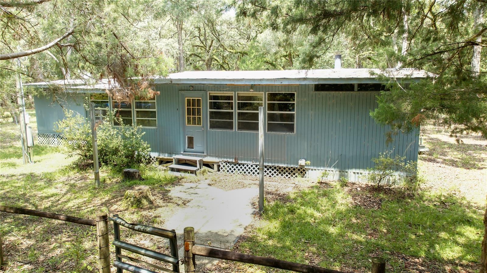 Escape to the peaceful charm of Old Florida with this picturesque 5-acre wooded retreat. Tucked away among mature trees and abundant wildlife, this tranquil property offers the perfect canvas for your dream home or private getaway. The land is fully fenced and comes equipped with a well, septic system, and electric already in place—saving you time and upfront costs. A mobile home is currently on site and, with some TLC, could serve as a cozy fixer-upper or a temporary living space while you build. Enjoy the freedom of country living with room to roam, all while being just a short drive from town conveniences, the Suwannee River, and the Gulf. Don’t miss this opportunity to own a slice of Florida paradise.