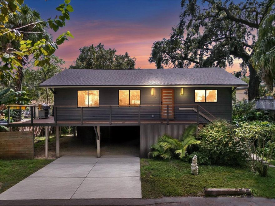 Welcome to this extraordinary modern home, a true one-of-a-kind retreat that has just undergone a complete and thoughtful renovation by a premier design-build firm. From the moment you arrive, you’ll notice the serene setting—nestled on a quiet, tree-lined street overlooking the tranquil Hillsborough River, this home feels like a hidden treehouse sanctuary while still being in the heart of vibrant Seminole Heights.
Every element of this property has been restored and updated to the highest standards. The home is elevated well above the flood zone, providing peace of mind and added security during storm season. Importantly, this property has never sustained hurricane damage, a rare and valuable feature for a waterfront-adjacent home in Tampa Bay. Inside, the open layout is anchored by gleaming hardwood floors, modern recessed lighting with dimmers, and custom cabinetry designed to maximize storage and functionality. The kitchen blends sleek design with practicality, showcasing polished concrete countertops, brand-new appliances, and stylish finishes that will impress any home chef. The spacious living areas flow seamlessly to the outdoors, filling the home with natural light and creating a true indoor-outdoor lifestyle. The primary suite has been reimagined as a spa-like escape, featuring a luxurious ensuite bathroom with a large glass-enclosed shower, a deep soaking tub, custom built-in bedside sconces, and designer finishes. Additional updates include a new roof, updated plumbing and electrical systems, a high-efficiency HVAC, a new fence, and a striking custom Mahogany front door with smart lock technology. Outdoor living has been carefully designed for relaxation and entertaining. A large elevated deck with sleek modern cable railing overlooks the lush landscape, offering the perfect place for morning coffee or evening gatherings under the trees. Beneath the home, you’ll find an abundance of additional storage space, including a custom-built shed—ideal for housing kayaks, paddleboards, bicycles, tools, or seasonal items. Beyond the property itself, the location is unmatched. Seminole Heights has become one of Tampa’s most sought-after neighborhoods, known for its thriving food and craft beer scene, local art, weekly markets, and strong sense of community. Despite the home’s tucked-away setting along the river, residents here enjoy quick access to downtown Tampa, major highways, and some of the city’s best cultural and recreational offerings. This is more than a home—it’s a rare opportunity to own a fully modernized retreat in one of Tampa’s most distinctive neighborhoods. With every detail thoughtfully considered, elevated construction for long-term security, and a setting that blends natural beauty with urban convenience, this property is ready to welcome its next fortunate homeowner.