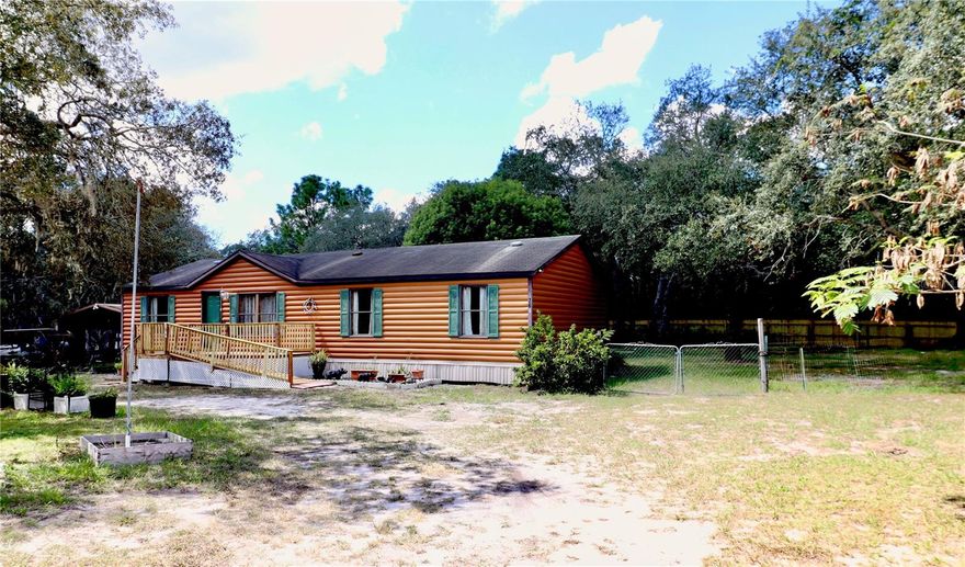 Tucked away on a quiet street sits this cozy half acre lot with an updated 3 bedrooms and 2 bathroom home. Driving up, you will be greeted to a spacious yard with great curb appeal, a 2-car steel carport & a wheelchair ramp— for handicap accessible entry into this adorable home! Upon entering through the keyless entry front door you'll be welcomed inside to the wood burning fireplace— a great focal point for the oversized living room, showcasing new Luxury Vinyl Laminate flooring (2025) throughout with moisture barrier, new lighting  & fresh paint throughout (2025). Off the living room is the adjoining dining area, with an open kitchen, designated laundry space, and access to the New back deck (2025)— overlooking the serene fenced backyard, perfect for your pets and watching the grazing horses! Back inside, the open concept floor plan is great for entertaining! The kitchen flows freely into both shared spaces and features wood cabinets, an eat-in area, and is stainless steel appliance ready!  Off the main living area is the owner's retreat, featuring a large walk-in closet, and a spacious updated ensuite— with soaking tub, handicap-friendly shower, new vanity, mirrors and extra storage. On the opposite side of the home, for additional privacy, are the two comfortably sized spare bedrooms, both with new carpet (2025) and a shared bathroom, with a new shower, large vanity, and toilet (2024). A few more great perks— HVAC (2020), Newer Hot Water Heater, fenced yard, and two generous sized storage sheds for all your toys and tools! Great location and NO FLOOD ZONE, WHICH SAVES YOU MONEY!