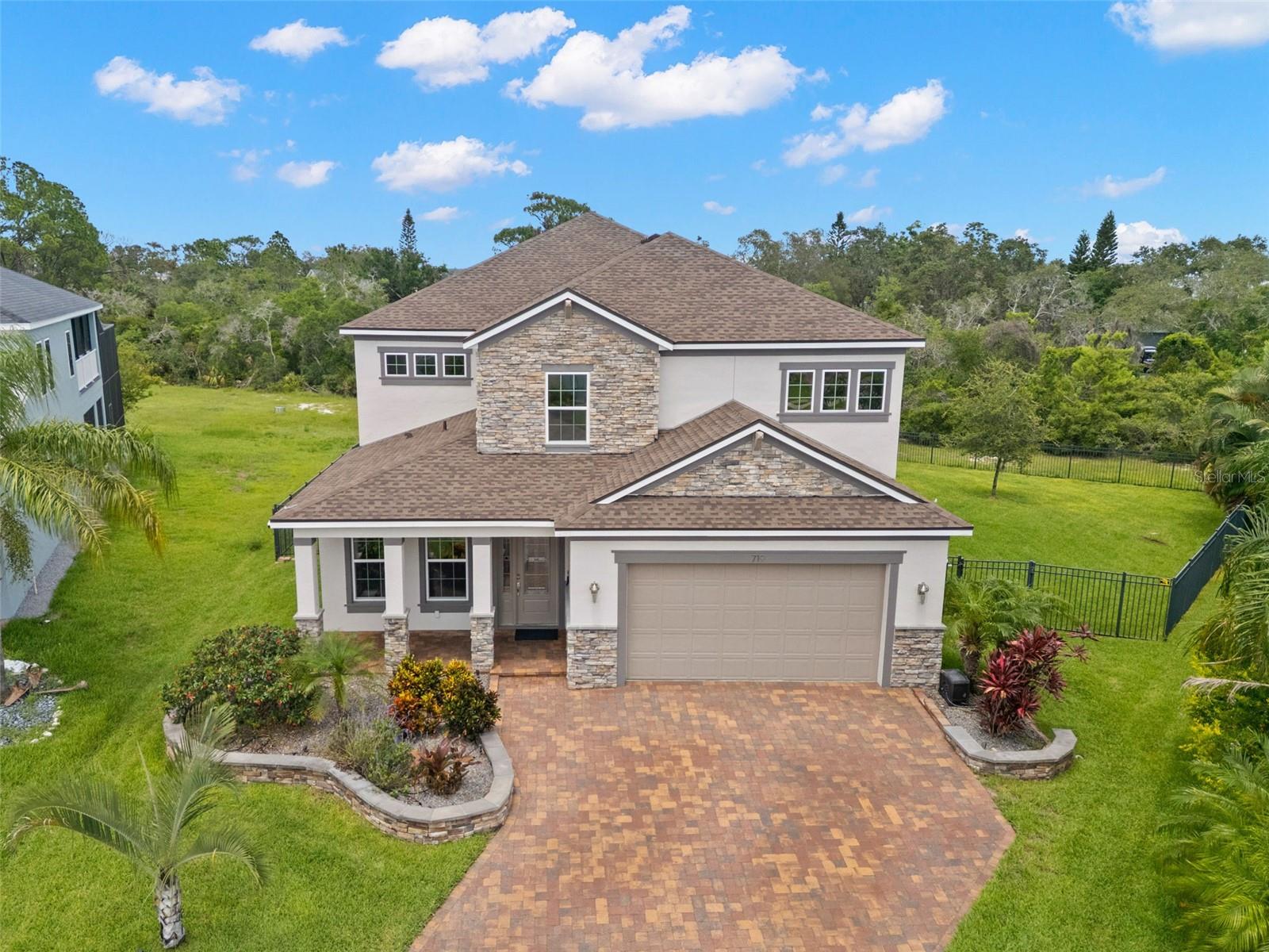 Stunning 5-Bedroom, 3.5-Bath Home w/Flexible Living Space in Prime Tarpon Springs Location! With a NEW roof, NEW hot water heater, NEW refrigerator & newer appliances (all 2018) plus a whole house water filtration system, there is nothing to do except for move in! This elegant & spacious two-story home in the heart of Tarpon Springs offers an abundance of versatile living space designed for modern lifestyles. From the moment you arrive, you'll notice the attention to detail—starting w/the brick-paved driveway leading to your oversized two-car garage, & a charming front porch perfect for morning coffee and peaceful evenings. Step inside to soaring high-volume ceilings that create a grand, open feel throughout. Off the foyer is your formal living room, ideal for entertaining or quiet relaxation. Down the hall, you’ll find a convenient half bath, storage closet, & garage access. At the heart of the home is the open-concept kitchen, family room, & dining area, perfect for hosting gatherings or daily family living. The kitchen is a chef’s dream w/rich wood cabinetry, gorgeous quartz countertops, stylish architectural tile backsplash, oversized walk-in pantry w/built-in shelving, large center island w/ breakfast bar seating. The attention to detail & high-end upgrades throughout the home are evident at every turn. The two-story family room is a true showstopper, featuring a dramatic floor-to-ceiling stacked stone fireplace and sliding glass doors leading to the wraparound screened lanai—an ideal extension of your living space. The dining area is generous in size and also provides lanai access through a second set of sliders. Tucked just off the main living space is a flexible first-floor suite that could serve as an in-law suite or first-floor primary bedroom. This area includes large bedroom w/adjacent bonus room/home office, beautiful en suite bath with dual-sink vanity, step-in shower, private water closet, and linen storage. The spacious walk-in closet with custom built-ins and pull-out drawers plus stackable washer/dryer (2019) rounds out this terrific bonus space. Upstairs, you’re greeted by a loft area overlooking the family room below—perfect as a media room, game room, or second living room space. 3 additional bedrooms all offer walk-in closets & plush carpet, and share a full hall bathroom w/a tub/shower combo. Additionally, there is a second floor laundry room that offers hook-ups for a washer/dryer and offers extra storage space, too. Retreat to the upstairs primary suite, a private oasis featuring a separate sitting room plus direct access to a private porch, a luxurious en suite with two separate vanities, deep soaking tub, step-in shower with rain shower head, private water closet, and linen closet. The expansive walk-in closet boasts custom drawers and organizers. The fully fenced backyard provides a secure and serene outdoor space—perfect for pets, play, or creating your dream garden or entertaining area. Notable Features include elegant, high-end finishes throughout, tons of flexible living space, multiple bonus rooms, and thoughtfully designed storage solutions, central vaccum, new paint March of 2025, New upgraded HWH and water purifier and a new sealed driveway. Ideally located near top-rated schools, parks, shopping, and all the charm of Tarpon Springs—including the famous Sponge Docks and beautiful beaches. Don’t miss your opportunity to own this thoughtfully designed, move-in-ready home with room for everyone. WOW!