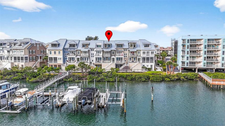 Experience refined coastal living in this beautifully appointed four-story waterfront townhome in Indian Shores, offering one of the finest views in the community. Just steps from the beach and the private community dock, this light-filled residence showcases sparkling water views on every level, wood flooring, crown molding, high ceilings, impact-rated windows and doors, and a private elevator servicing all floors. The designer kitchen overlooks the living and dining areas, creating an elegant space for entertaining. Custom cabinetry, high-end fixtures, a Sub-Zero refrigerator, premium Wolf range, gas cooking, instant hot-water tap, and abundant storage complete this true chef’s kitchen. This level also includes a stylish powder room. Balconies on each floor capture unobstructed vistas of the Intracoastal Waterway. The third floor hosts the primary suite with two generous walk-in closets—one currently used as an office—along with a luxurious en-suite bath featuring dual sinks and an oversized shower. A private balcony extends from the primary suite. A secondary bedroom with its own en-suite bath and custom built-ins, along with a conveniently located laundry room, complete this level. The fourth floor offers a versatile third bedroom or flex space—ideal as an office, library, or fitness room—featuring its own en-suite bath and the home’s most secluded balcony. The newly painted garage accommodates three cars with ample additional storage. Recent upgrades include a new water softener and whole-house filtration system. With breathtaking 180-degree water views, a community boat slip, a heated pool, and effortless access to the white-sand beaches of Indian Shores, this exceptional home embodies the very best of luxury coastal living.