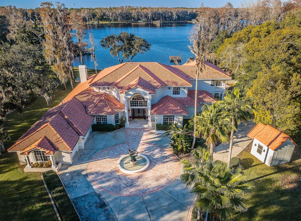 TAKING BACK UP OFFERS. FORTUNE 500 EXECUTIVE ELEGANCE IS YOURS ACROSS THE SWEEPING PRIVATE GROUNDS OF THIS EXTRAORDINARY, LUXURY WATERFRONT ESTATE. Private gated entry on a deep, sprawling 1+ acre lakefront lot, introduces a spectacular residence with extraordinary attention to detail. A long circular drive leads to a majestic 20ft-high covered travertine entry – hinting at the captivating charm to follow. Towering 22ft-high foyer reveals an expansive feel of luxury with stunning views of your private waterfront. Superbly polished marble floors, splendid Roman columns, lavish woodworking/alcoves, remarkable ceiling finishes, and graceful window treatments deliver a richness and refinement rarely found in today’s homes. Plush living room enjoys a chic, dedicated wetbar while the spacious and stately formal dining offers a genteel appeal. The sumptuous open-concept kitchen boasts fine granite counters, raised-panel wood cabinetry, large wrap-around bar, center island gas cooking, pantry wall, dedicated work center and casual dining overlooking the pool deck. The open and airy family room, with granite/wood trim gas fireplace, enjoys fabulous lake views thru striking frameless glass windows. Enter the impressive owner’s suite and be taken to a place of pampered indulgence; huge bedroom has large adjacent executive office and sizable sitting area with access to the pool. Plush owner’s bath provides gorgeous marble finishes, marble-encased jetted spa tub, granite surfaces, dual vanities, dedicated cosmetics center, lovely walk-in shower and 2 large walk-in closets, one with terrific cherrywood finishes. Magnificent marble/granite flying staircase leads to an eye-catching 360sqft open loft with access to a grand 38ft-wide covered balcony with commanding views of the lake. Large private waterfront sitting room transitions to a plush executive suite with opulent flooring/bath/closet system, and a private covered balcony overlooking the water. Separate bedroom suite has full bath, dual closets and private access to covered lake-front balcony. Out back, discover covered a huge travertine paver deck with infinity pool that seemingly spills into the lake. Elevated hot tub/pool offer pebble-sheen surfaces, numerous fountains, waterfalls, LED lighting, and shellstone/travertine trimwork. Pool deck has a brilliant cooking/dining center and elegant full pool bath. The estate includes a separate full-service guest home and countless extras. A fantastic luxury value in a great location!