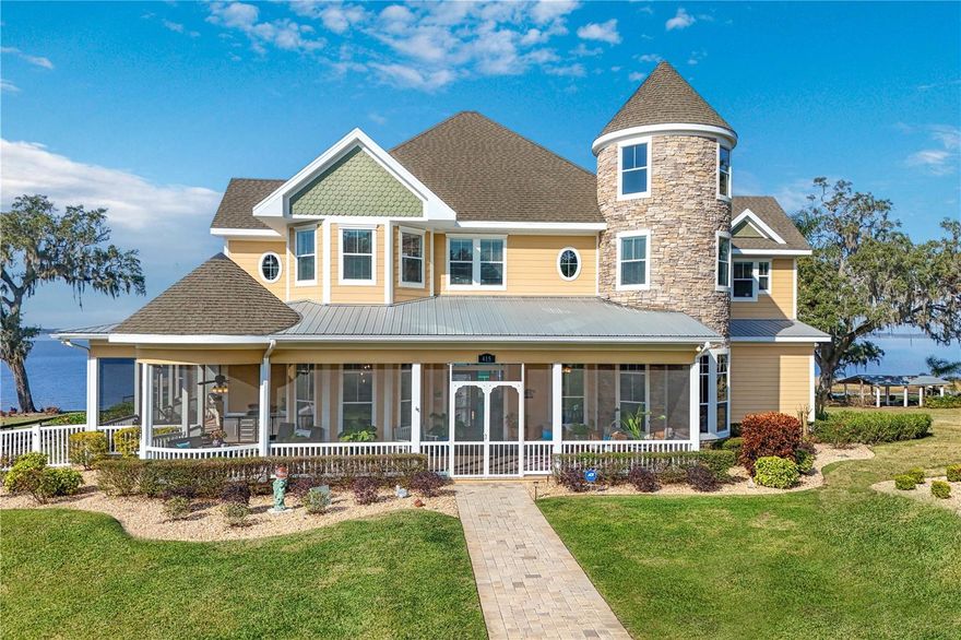 Exclusive Lakeside Estate on the Harris Chain of Lakes – A Rare Opportunity
Welcome to a breathtaking 6-bedroom, over 6,500 sq. ft. estate nestled on 3+/- pristine acres with 120 +/- feet of direct lakefront access to the sought-after Harris Chain of Lakes. Designed for those who demand privacy, elegance, and the ultimate waterfront lifestyle, this gated estate is a masterpiece of design and craftsmanship, offering an unparalleled blend of natural beauty and refined luxury.  You will follow a long, landscaped drive after passing through the gated entrance, unveiling an architectural gem coming into view that exudes grandeur.  Once you step into the front screened porch, your mind will be full of possibilities. The screened front porch & surrounds the front of the home offering several different options for seating, eating & taking in the beauty. Then, just inside the expansive foyer, the soaring ceiling and wall-to-wall windows immediately capture breathtaking views of the lake and sportsman pool. The open layout and meticulous design create a seamless flow between indoor and outdoor living, making this home a true retreat. The chef’s kitchen is a culinary dream, featuring top-of-the-line professional appliances, a gas cooktop, double ovens, and an impressive octagonal island, perfect for hosting gatherings. Plenty of room in the kitchen nook and bar stool seating for informal meals, with the formal dining room offering an elegant setting for dinner parties, while the adjacent living spaces boast custom finishes, a grand fireplace, and expansive lake-facing windows that flood the home with natural light.
The front wraparound screened porch invites relaxation, while the air-conditioned rear screened porch is the ultimate spot to soak in picturesque lake views and breathtaking sunsets. This is truly a Resort-Style Outdoor Oasis. Designed for luxury lakefront living, the resort-style pool area is surrounded by a glass fence, ensuring unobstructed water views & surrounded by freshly sealed & grouted Travertine. The recently updated pool pumps ensure worry-free maintenance, while multiple AC zones keep the home comfortable year-round. Extensive lightning rods have been added for protection. The private boathouse with a boat lift allows for effortless access to the pristine waters of the Harris Chain of Lakes, where world-class boating, fishing, and water sports await. This is lakeside living at its finest. The first-floor master suite is a sanctuary of sophistication, complete with a romantic two-sided fireplace, a spa-inspired en-suite bath with a soaker tub, and a private sitting area overlooking the lake. Upstairs, five additional bedrooms and baths provide ample space for family and guests, while a grand bonus room offers versatility for a game room, theater, or home gym. The Rapunzel tower holds a hidden secret attic retreat, adding a whimsical and charming touch to this extraordinary home. Some additional features of this magnificent estate include:
 • Detached garage with the potential for a full in-law suite or guest apartment above
 • A separate barn & workshop – ideal for car collectors, featuring an air-conditioned office
 • Lushly landscaped grounds with mature trees, ensuring privacy and tranquility
This exclusive lakeside estate is more than just a home—it’s an experience. Offering the perfect balance of luxury, privacy, and waterfront serenity, this property is ideal for those who appreciate the finer things in life.