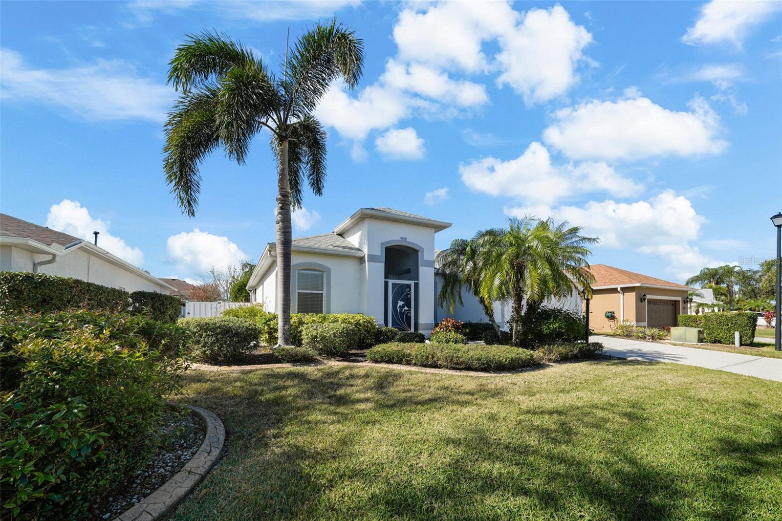 This immaculate Golf Course Home sits in a prime location! Just 10 minutes from I-75, Costco, and Lakewood Ranch. This solid concrete block home offers 1,797 sq. ft. of comfort and style in the heart of convenience. Enjoy the close proximity to schools, shopping, healthcare, fitness, dining, and your local Starbucks.
Inside, the split floor plan features 3 bedrooms, 2 bathrooms, and a laundry room. Three sets of sliding glass doors from the primary suite, dining area, and den create seamless indoor/outdoor living. The spacious kitchen with a bar that seats five opens to the great room, making it the perfect space for entertaining.
The primary suite includes two closets, large vanity with dual sinks, a walk-in shower, and soaking tub. 2 additional bedrooms and the hall bath are located on the other side of the house, adjacent to the den.
Step outside to the 567 sq. ft. screened patio, complete with a covered area, two ceiling fans, and plenty of room for relaxing or dining al fresco. The screened front entry also allows for refreshing cross-ventilation.
Have you been searching for a low-maintenance home in pristine condition within a welcoming golf course community?
Look no further. You've found it! Schedule your private showing today!
Photos were taken during the time the house was staged with furniture and accessories.