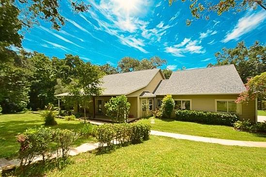 Discover your perfect country retreat on this secluded 10-acre lot, with 4 bedrooms & 3 bathrooms offering privacy, space, and a host of modern updates. This charming home is nestled in a peaceful setting and designed for rural living. Inside, you’ll find an open floor plan featuring rich hardwood floors, a cozy fireplace, and spacious bedrooms that provide ample room for relaxation and comfortable living. Looking for multi-generational space? The fourth bedroom has a private entrance and ensuite bathroom. Recent upgrades make this property move-in ready and built to last, including two brand-new AC units (2022 & 2023), a NEW ROOF installed in 2024, and a comprehensive water filtration system to ensure clean, quality water throughout the home. Upgraded Double Pane Windows keep the electric costs low. The layout is ideal for entertaining, with the living, dining, and kitchen areas flowing seamlessly together, filled with natural light and warmth. Step outside on the expansive elevated back deck overlooking the firepit & pergola and acreage filled with trees and birds. A large pole barn offers storage for your recreational vehicles and features an RV hookup—perfect for guests or travel convenience. Shed/Workshop is equipped with electric and is located next to the chicken coup. Whether you need space for outdoor recreation, or simply want a tranquil escape, this property delivers. Located well off the road for ultimate privacy, this country gem combines the best of rural charm with modern comforts. Don’t miss the opportunity to make this rare and versatile property your own. It's only 2.5 miles to access I-75, 38 miles to Downtown Tampa & about 60 miles to the beautiful Gulf coast beaches.