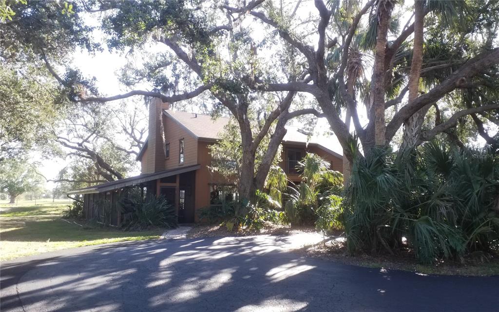 HUGE PRICE IMPROVEMENT! You have to check out this home. MAGNIFICENT 5 BEDROOM 4 BATH CUSTOM BUILT HOME ON 5.4 ACRES THAT BACKS UP TO PARADISE GOLF COURSE. As you enter the foyer, you will be amazed by the openness of the great room, with the 2- story stone wood burning fireplace, tongue and groove cabinetry and high ceiling complete with skylights to allow natural sunlight. The gourmet kitchen is the perfect spot for cooking those amazing meals and entertaining your friends and family. The family room is open to the kitchen and has a beautiful custom fireplace. The master suite is located on the main floor along with the office and huge game room. As you move upstairs you will find super views of the great room and it has another master suite plus 3 more bedrooms. The lanai area is just as amazing as the rest of the home, details are everywhere. Perfect spot to hang out and enjoy the quietness of this area. The car port area is built with the same materials and craftsmanship as the main home and has a workshop and golf cart area. Roof was replaced 9 months ago, and a new septic system complete with lift station was installed last year. 3 zone AC and water heater only a year old. This is a one-of-a-kind home that provides privacy and all the amenities you would look for in a custom-built home. Schedule your private showing today.