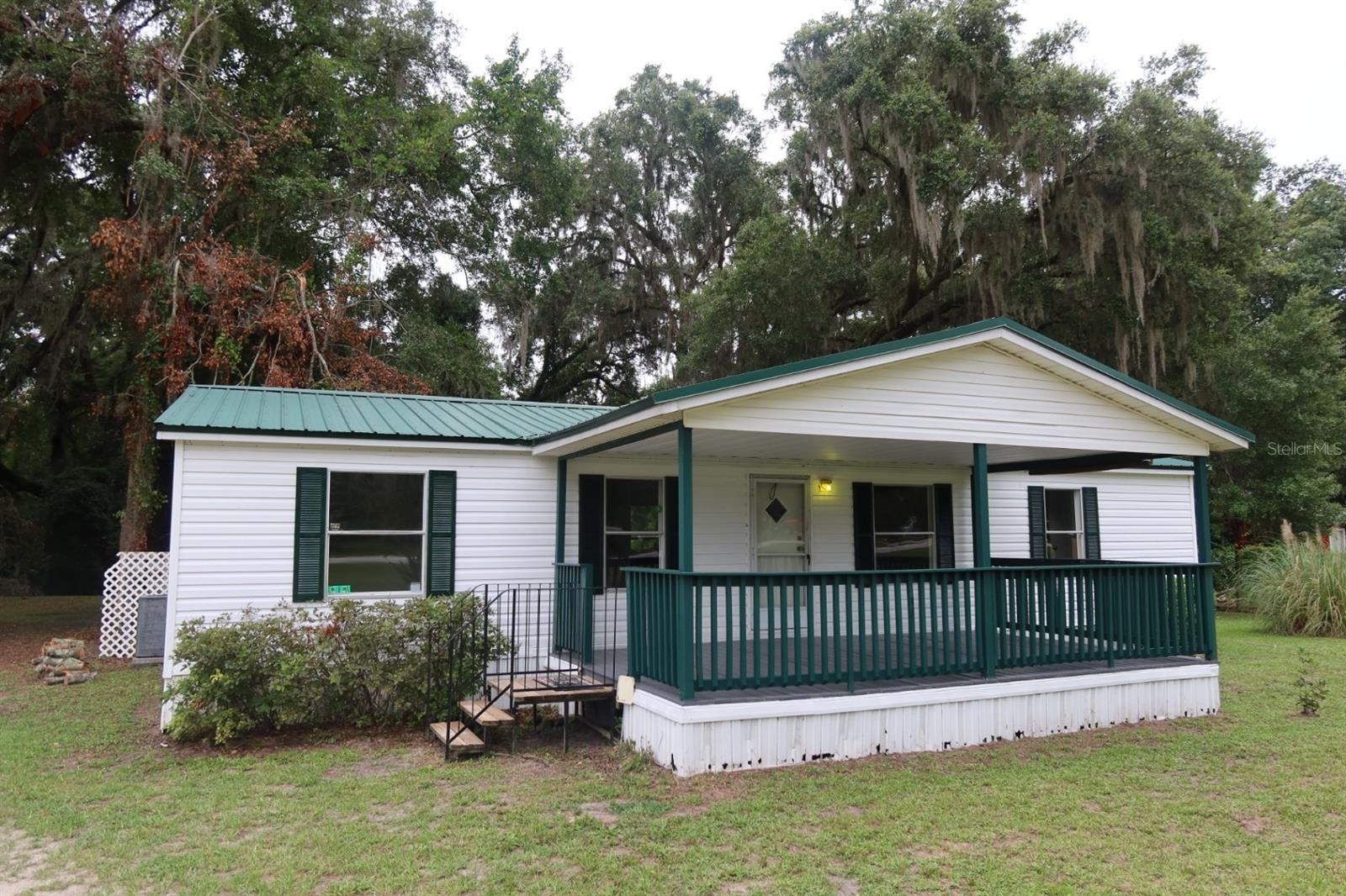 Welcome to this 3 bedroom, 2 bath manufactured home nestled on a spacious lot in peaceful Lake City, Florida. A metal roof, fresh exterior paint, and a front porch addition, this home offers privacy, and room to grow, whether you're looking for a full-time residence, or an investment opportunity! Step inside to find a split bedroom, open floor plan with a large primary suite featuring a walk-in closet and a private bath. The open-concept living and dining areas provide plenty of natural light, and the kitchen includes ample cabinetry with counter space for meal prep or entertaining. Enjoy country living with over an acre of cleared land, perfect for gardening, pets, playing catch, or even future additions. Located just a short drive from Lake City, I-75, shopping, schools, and parks, this property combines country living with convenient access to everything you need! Don’t miss this opportunity to own a slice of North Florida tranquility!