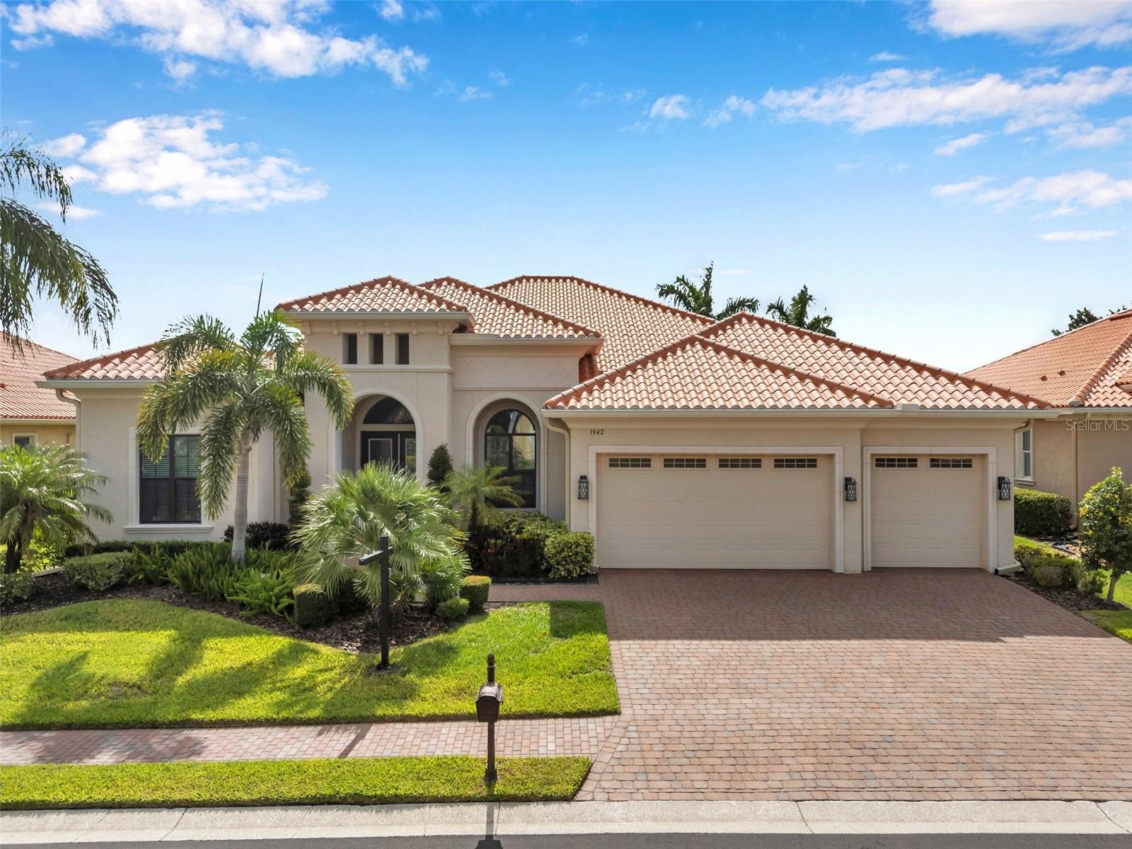 Presenting one of the NEWEST homes (2018) in the gated Siena enclave of the prestigious Champions Club community — featuring a timeless Mediterranean exterior combining perfectly with a contemporary style and a wonderful layout inside. From the portico through the double door entry, the foyer creates the perfect pause before entering the open living spaces where 12ft ceilings create an enhanced sense of space while architectural details subtly define each area making the layout perfect for all occasions. Stacking sliders offer the option of extending to the outdoor living spaces. The formal dining room is such a pleasing space it begs you to plan dinner parties— perfectly positioned with easy access to the dry bar and buffet.
The kitchen features an abundance of espresso cabinetry, quartz counters, double wall ovens, a natural gas cooktop and exhaust hood. A built in buffet offers extra cabinet and counter space and a huge walk-in pantry completes all the storage space you could need. An expansive breakfast bar island with attractive pendant lighting, and a dining nook offer options for informal dining.
The spacious primary suite in the split plan layout makes the perfect owners retreat and features a wonderful custom walk-in closet and a huge bathroom with two separate vanities, a standalone soaker tub and a walk-in shower enclosure. Two guest bedrooms on the other side of the home either side of a full guest bathroom provide comfortable private accommodations while the fourth bedroom with a custom sand blasted glass door is currently functioning as a large bonus room but could potentially serve as an in-law suite. The laundry room features everything you could hope for with cabinets, a granite folding counter, a hanging rail and cabinets. Outdoor living space is provided by an expansive private screened patio and lanai and is paved with travertine and features an outdoor kitchen and a striking basalt sculpture. There is room for a private pool or hot tub, should you desire. The garage has an EV charger, a mini split AC system and epoxy flooring to allow you to use it as a gym or a workshop. The champions club provides fabulous amenities just for residents, including a clubhouse, a sparkling community pool, tennis, pickleball, community activities and basketball — check out the Champions club website for details. Conveniently located for access to shopping, Trinity medical center, entertainment, airports, beaches and everything the Tampa Bay area has to offer. Be sure to check out the VIDEO link to see the home in motion.