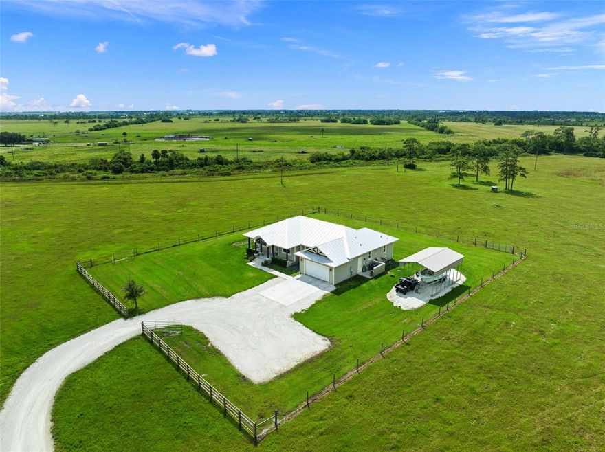 Nestled in the tranquil northeast region of Okeechobee, this custom-built CBS home awaits you! Set on 10 acres of serene countryside, this spacious three-bedroom, two-bath home with an office and 2-car garage is a rare find. Built in 2016, the property offers 1,897 sq. ft. of living space under air and boasts breathtaking views of endless pastures. The split floor plan provides both space and privacy in the home. Special features include engineered hardwood flooring throughout the living areas, a tongue and groove cypress ceiling in the living room, and an open kitchen with stainless steel appliances and a breakfast bar for casual dining.  Escape to your private oasis in the spacious master suite with a generous walk-in closet, a bathroom with double vanities, and a walk-in shower.  You'll enjoy working from home in the sunny office and at the end of the day relaxing on the screened back porch with picturesque views. There is covered boat or vehicle storage perfect for those with outdoor hobbies or multiple vehicles.  Don't miss the chance to own this piece of paradise!  This home is located on a private gated road so it is not possible to drive by to view it.