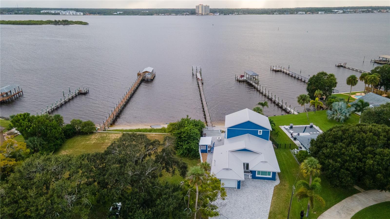 YOUR INTERCOASTAL RIVERFRONT TRANQUILITY AWAITS! THIS UNIQUE HOME OFFERS A LOW MAINTENANCE EXTERIOR COMBINED WITH AN OPEN FLOORPLAN FEATURING PANORAMIC RIVER VIEWS AND OUTDOOR ACCESS. A FULL REMODEL WAS COMPLETED IN 2022 WITH EXTERIOR IMPROVEMENTS TO INCLUDE: CONCRETE BLOCK AND CEMENT HARDI BOARD CONSTRUCTION, METAL ROOF, UPGRADED INSULATION, ALL IMPACT GRADE WINDOWS AND STACKING SLIDERS, A 250 FT DEEP WATER DOCK & 15K OPEN TOP BOAT LIFT, A LARGE WRAP AROUND PAVERED PATIO WITH ENCLOSED SUMMER KITCHEN (PERFECT FOR ENTERTAINING), SHADED BY A REMOTE CONTROLLED 20 FT SUNSHADE, JUST TO LIST A FEW. THE INTERIOR PROVIDES LARGE ROOMS WITH SPECTACULAR WATER VIEWS, CROWN MOULDING, CELING FANS AND SO MUCH MORE.. THE MODERN KITCHEN OFFERS GENEROUS STORAGE WITH CUSTOM CABINETS, A LARGE QUARTZ BREAKFAST BAR, STYLISH APPLIANCE PACKAGE AND A DINING NOOK WITH RIVER VIEWS AND PATIO ACCESS, ALL WHILE CONNECTING YOU TO THE LIVING AND FAMILY ROOMS. HIGH GRADE ENGINERED LAMINATE FLOORING FLOWS THROUGHOUT THE HOME, ACCENTING THE LARGE ROOMS GENEROUS AMBIENT LIGHT & THE INTERCOASTAL RIVER VIEWS. LIGHT LEVELS AND PRIVACY ARE MODIFIED BY REMOTE CONTROL WINDOW TREATMENTS. FEATURNIG DOUBLE MASTER BEDROOMS WITH ENSUITE BATHS, THE MAIN FLOOR MASTER BEDROOM IS HANDICAPP ACCESSIBLE, WITH WALK IN CLOSET. THE ENSUITE BATH HAS WALK IN SHOWER AND LARGE VANITY WITH QUARTZ COUNTERTOP. THE SECOND FLOOR MASTER BEDROOM INCLUDES A PRIVATE BALCONY COMPLETE WITH WATER & POWER AS WELL AS REMOTED CONTROLLED SCREEN PERFECT FOR THE EVENING BREEZES. THE ENSUITE BATH FEATURES SPLIT VANITIES, WALK IN WRAP AROUND SHOWER SYSTEM, PRIVATE WATER CLOSET, TUB WITH SPA AND A GENEROUS WALK IN CLOSET. THE 3RD BEDROOM WITH DOUBLE CLOSETS AND ADJACENT GUEST BATH WITH QUARTZ COUNTERTOP VANITY AND A WALK IN SHOWER COMPLETE THE MAIN FLOOR INTERIOR LIVING AREA. THE EXTRA WIDE 1 CAR ATTACHED GARAGE WITH LAUNDRY SYSTEM AND THE OVERSIZED PAVERED DRIVEWAY ROUND OUT THE BEAUTY AND FUNCTIONALITY OF THIS MUST SEE HOME. SCHEDULE YOUR APPOINTMENT TODAY!