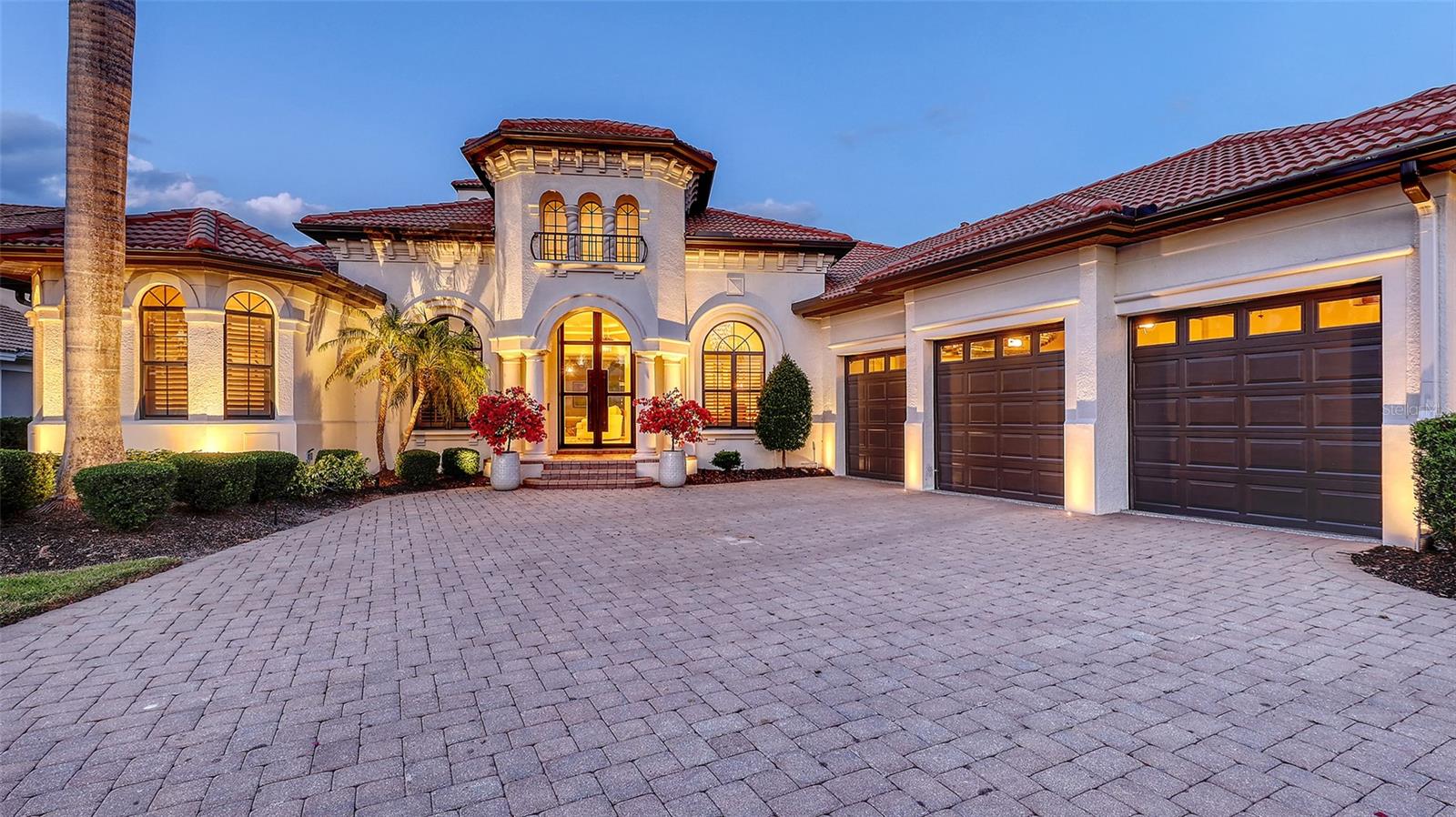 Live the Lifestyle You've Been Dreaming Of in Lakewood Ranch Country Club!
Perfectly positioned on one of the premier homesites in Lakewood Ranch Country Club, this exquisite custom-built estate offers panoramic views of the shimmering lake and rolling fairways—setting the tone for an extraordinary living experience. Encompassing nearly 5,000 square feet of refined interior space, this residence effortlessly blends timeless elegance with modern updates.
From the moment you arrive, you're greeted by stately iron double doors that open to a grand foyer, where soaring ceilings, graceful archways, and rich architectural details unfold. The formal living room is a showstopper with coffered ceilings, a gas fireplace framed by a stone mantle, and picture-perfect views. Host with ease in the formal dining room or indulge your inner chef in the gourmet kitchen, showcasing Brookhaven cabinetry, quartz countertops, a striking quartz backsplash, 6-burner gas cooktop, pot filler, double ovens, warming drawer, and an expansive walk-in pantry—complete with a second refrigerator.
Retreat to the luxurious primary suite with custom-built walk-in closets, a double tray ceiling, engineered wood floors, and tranquil views. The spa-like bath offers a Roman shower, jetted tub, dual vanities with granite counters, and richly appointed cabinetry. Two additional en-suite bedrooms on the main floor provide privacy and comfort for family or guests, while the dedicated office with custom built-ins and a spacious bonus room with sliders to the lanai add flexibility to suit your lifestyle.
Upstairs, a fourth bedroom, full bath, and media/bonus room with access to a balcony offer the ideal setting for guests or a private retreat, with sweeping views that must be seen to be believed.
Step outside to your private backyard oasis where the expansive lanai is designed for year-round enjoyment. Lounge by the saltwater pool and spa, entertain under the covered outdoor living spaces with a fully equipped summer kitchen, or gather around the outdoor fireplace for cozy evenings under the stars.
Located within the gates of Lakewood Ranch Country Club, residents enjoy access to optional memberships to world-class amenities including 4 championship golf courses, a state-of-the-art fitness center, tennis and pickleball courts, fine and casual dining at the private clubhouses, and a vibrant social calendar.
Beyond the gates, Lakewood Ranch is consistently ranked as one of the top master-planned communities in the country, offering top-rated schools, medical facilities, scenic parks and trails, and a thriving Main Street with shopping, dining, and entertainment—all just a short drive to the white sand beaches of the Gulf Coast.
This is more than a home—it's a statement of lifestyle, elegance, and Florida living at its finest.