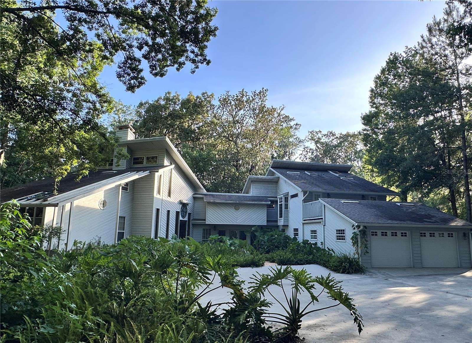 Extraordinary Custom Home with Stunning Views of Ravine and Cavern – A True Sanctuary in Ocala.
Step into a truly unique sanctuary, nestled amidst Florida’s natural beauty, offering an unparalleled combination of privacy, modern comfort, and breathtaking views. Set back from the road and nestled within a tranquil natural landscape, this custom-built four-bedroom, four-and-a-half-bathroom home offers both seclusion and serenity, with stunning views from every room. Whether you're seeking a unique full-time residence or a retreat for weekend getaways, this property offers the perfect blend of indoor/outdoor living spaces, designed for relaxation and easy entertainment.
Key Features:
Four Bedrooms, Four and a half bathrooms
5287 square feet (under heat and air conditioning)
Incredible Views: Every room is designed to capture stunning views of nature, with walls of windows that flood the home with light.
Ravine and Cavern: Lime rock cliffs lead to a valley filled with native plant life. Soaring trees are home to many species of birds. A creek bed fills with water during periods of heavy rain and flows into the cavern, eventually leading to the Floridan Aquifer.
Privacy & Seclusion: Set away from the road, the home is tranquil, quiet, and private. With three levels of wrap-around decks, you’ll find the perfect space to enjoy everything from sunbathing to yoga, cocktails with friends, or simply relaxing while soaking in nature’s beauty.
Spacious Primary Suite: The entire second floor is dedicated to the luxurious primary suite, with a separate bathroom for each partner. The expansive space includes soaring ceilings, natural wood finishes, and a private sanctuary-like ambiance.
Private Quarters for All: Each bedroom occupies its own wing or level of the home for maximum privacy.
Entertainment-Ready: The home is designed for effortless indoor and outdoor entertaining, with a flexible layout that includes a modern granite and stainless kitchen, spacious dining areas, and ample room for gatherings.
Guest/Flex Space: A separate guest suite or flex space with a private entrance and kitchenette ensures privacy for visitors.
Modern Amenities: Featuring a well-equipped kitchen with two convection ovens, a deep, farmhouse-style sink, built-in bookcases in the loft library, and a spa bathroom, this home is as functional as it is beautiful.
Gym & Wellness Space: A private gym space and soothing, deep-soaking tub give the perfect way to unwind and focus on self-care. Additional spaces like a loft library, private offices, private sunbathing area, and ample storage areas provide the flexibility you need to customize this home to fit your lifestyle.
Solarium: A large, attached solarium allows you to immerse yourself in the changing seasons, the shifting light, and the tranquil sights and sounds of nature, all while remaining sheltered and comfortable. It creates a space that fosters relaxation, creativity, and wellness, whether you're basking in the warmth of the sun.
Additional Features: Separate storage for your toys, with a separate entrance for a golf cart, bikes, or an ATV, a 2-car garage convertible to a four-car capacity, and a private, spacious office area. A beautiful hand-made stained-glass window and high-end finishes throughout, a marble wood-burning fireplace, including a dramatic steel spiral staircase leading to the loft library.