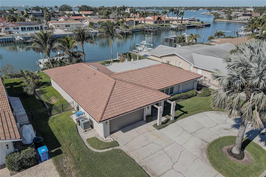 LIVE YOUR LUXURY in this immaculately turn-key waterfront residence located in the highly sought-after Broadwater neighborhood of St. Petersburg. High and dry during recent storms, this desirable home is positioned on a wide canal with protected sailboat water, offering swift access to the open Gulf. Enjoy the best of coastal living—just 10 minutes from the vibrant energy of Central Avenue and another 10 minutes to St. Pete Beach.
Situated on a 0.23-acre waterfront lot with mature tropical landscaping and serene water views, this 4-bedroom, 3-bath home offers 2,343 square feet of refined, open-concept living thoughtfully designed for elevated coastal lifestyles.
Porcelain tile flooring flows throughout the interior, complemented by high ceilings, crown molding, and French doors that create seamless indoor-outdoor living. The chef-inspired kitchen is a standout feature, showcasing solid wood cabinetry, stone countertops, high-end appliances, a bar refrigerator, and a striking statement range hood—all opening effortlessly to the main living space. A split-bedroom floor plan provides privacy, with a spacious primary suite featuring a walk-in closet and a beautifully updated bath.
Step outside to your private waterfront retreat, complete with a saltwater pool and heated spa, fenced yard, and an expansive deck ideal for entertaining. Boating enthusiasts will appreciate the 13,000-lb boat lift, approximately 80 feet of deep-water access, a 50-foot dock, and an accessible canal offering a quick five-minute sail from Boca Ciega Bay to the Gulf.
This is a rare opportunity to embrace the Broadwater waterfront lifestyle—where luxury, location, and livability converge.