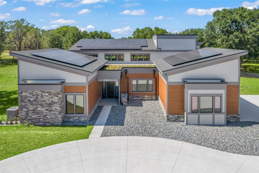 Under contract-accepting backup offers. One of a kind home in a one of a kind location! Bring your horses and animals, this home is zoned for agriculture and has NO HOA! This stunning, brand new custom home nestled on a private 10 acre gated lot offers an abundance of luxurious features and impressive modern style. A large circular drive and natural stone & wood facade create eye-catching curb appeal as you approach the front entry. As you step inside through the keyless smart lock front door, you will find yourself in a massive great room with a high vaulted ceiling, large floor-to-ceiling tiled fireplace, wet bar, and tons of natural light pouring in through the high windows on both sides as well as the quadruple-wide sliding doors, which adds to the bright and airy feel of this main living space. An exposed steel beam archway leads to the adjacent kitchen in this open-concept floor plan. The large gourmet kitchen offers ample counter space, sleek Scandinavian style wall-to-wall wood cabinets, a walk-in pantry, built-in fridge & freezer, built-in stainless steel oven and microwave, under-cabinet baseboard lighting, and a huge central cooking island with a 36 inch gas cooktop. Polished concrete flooring, exposed steel beams, and an impressive floating staircase with wire handrails bring industrial modern style to the home. Classic double doors lead to the generously oversized master suite, which features a large fireplace , massive walk-in closet with custom built-in shelving and drawers, and a spa-like private en-suite bath with a double-sink floating vanity, garden tub, and a spacious walk-in glass enclosed shower with dual rainshower heads. A private office is situated next to the master suite, offering the perfect work from home space, or an extra bedroom if needed. The two other bedrooms are located on the other side of this split floor plan home, and share the Jack & Jill bathroom which offers separate vanities for each room. Both rooms also feature custom built-in closet shelving and an accent wall with magnetic chalkboard paint. A large upstairs loft offers a great flex space perfect for a game room, home gym, or anything that best suits your needs. The loft also offers access to the large balcony with real Bahai grass. Downstairs, a large mud room, separate laundry room with a folding space and additional cabinetry, and a half bath complete the interior of the home. Continue out the sliding doors to the massive covered & screened in patio, where you will find a beautiful stone fireplace, a large outdoor kitchen complete with a sink, stainless steel grill, restaurant style vent hood, and a wine fridge, and ample room for entertaining and relaxing in this idyllic outdoor living space. In addition to the attached garage, a second 4-car garage with RV parking and a loft has also been newly built near the main house. Additional features include zoned AC with 3 separate top of the line Green Speed Carrier units with WiFi thermostats, App controlled Green Roof watering systems by Hunter BTT with Bermuda grass in the front and Bahai on the balcony, recessed & upgraded lighting throughout, Monogram smart kitchen appliances, tankless water heaters, solar panels, electronic remote control Hunter Douglas blinds, and much, much more! This home truly has too many features to list! Call today for a private tour!