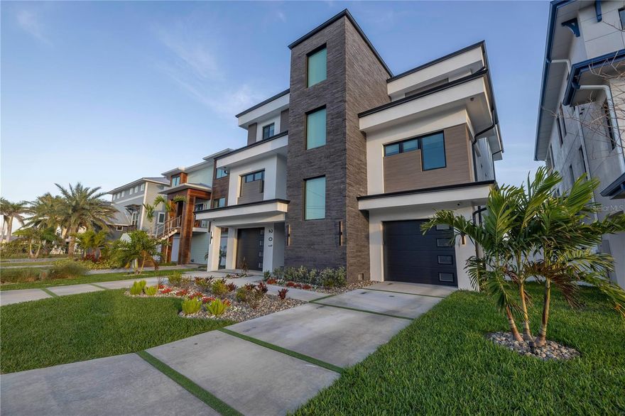 Welcome to an extraordinary waterfront oasis on St. Pete Beach, completed in late 2024, where modern luxury meets coastal charm. Nestled on a quiet road with only 26 homes, this custom-built masterpiece offers a rare opportunity to own a home that perfectly blends innovation, elegance, and the ultimate Florida lifestyle. Just steps from the world-famous sands of St. Pete Beach, this home is a true gem, designed to withstand the elements while delivering an unmatched living experience both indoors and out.  Best of all, it’s being offered fully furnished—just bring your toothbrush and start living the dream!
From the moment you step inside, you’ll be captivated by the thoughtful design and high-end features throughout. The gourmet kitchen is a chef’s dream, boasting top-of-the-line Thermador appliances, a gas range, two dishwashers, an oversized island, and a large walk-in pantry with a sink. With stunning views of Boca Ciega Bay as your backdrop, entertaining here is effortless and unforgettable. The living room exudes sophistication with its tranquil water vapor fireplace and tray ceiling with cove lighting, while the adjacent full bar—complete with three refrigerators, an ice maker, LED-lit displays, and a sleek modern pool table—creates the ultimate space for hosting and relaxing.  
The master suite is nothing short of spectacular, offering breathtaking water views and a handcrafted ceiling feature. The spa-like bathroom is a retreat in itself, featuring a fully enclosed steam shower, a separate soaking tub with a double-sided fireplace (with an option for privacy), a smart toilet/bidet, and a massive custom walk-in closet with a built-in island. Even the laundry room is designed to impress, with a separate clothes steamer for dry-cleaning convenience.
Step outside and prepare to be amazed by the outdoor living space, designed to elevate your waterfront lifestyle. The expansive area includes a fully equipped outdoor kitchen, a gas-heated spa that flows into the pool, a 13,000 lbs boat lift, a jet ski lift, a composite dock, and a new elevated seawall—all with breathtaking views of the bay. Whether you’re hosting a sunset gathering or enjoying a quiet morning by the water, this space is truly one of a kind.
This home is as functional as it is beautiful, featuring natural gas, a full-home Generac generator, two AC systems with a dehumidifier, an integrated Sonos sound system throughout, Hunter Douglas Electric Shades, and a fully equipped gym with a mini-split system. The all-masonry roof and elevator to all levels ensure convenience and durability, making this home as practical as it is luxurious.
Located just a short walk to the beach, this property offers the rare combination of waterfront living and easy access to the sugar-white sands of St. Pete Beach. Every detail has been meticulously considered in this one-of-a-kind custom home. Don’t miss your chance to own this modern masterpiece and experience the ultimate in Florida living!