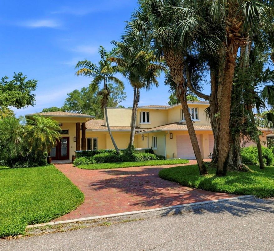 Tucked away in the coveted Bahama Shores neighborhood of South St. Petersburg, this extraordinary custom residence blends timeless craftsmanship, refined luxury, and relaxed coastal living just moments from Tampa Bay. Situated on an oversized lot surrounded by lush tropical landscaping, this impressive 4 bedroom, 4 bathroom home offers exceptional space, character, and functionality both inside and out.

From the moment you arrive, the striking curb appeal, expansive brick paver driveway, mature palms, and architectural presence set the tone for what awaits inside. The thoughtfully designed interior showcases a seamless mix of warm hardwood flooring, rich custom millwork, soaring ceilings, and expansive living spaces filled with natural light. The gourmet kitchen is a true centerpiece featuring custom wood cabinetry, stone countertops, stainless steel appliances, wall oven, built-in microwave, a center island, and generous prep and storage space ideal for entertaining or everyday living.

The spacious main living areas offer effortless flow between formal and casual spaces, including a stunning great room with elegant finishes, a formal dining area, breakfast nook, and multiple gathering spaces designed for comfort and entertaining. A dedicated game room with a custom built-in bar, billiards area, and nautical-inspired details creates the ultimate entertainment retreat. Additional flex spaces provide endless possibilities for a home office, library, fitness area, or guest accommodations.

The private primary suite serves as a peaceful escape with oversized proportions, beautiful natural light, and a spa-inspired ensuite bath with contemporary finishes and dual vanities. Generously sized secondary bedrooms and updated bathrooms provide comfort and flexibility for family and guests alike.

Outdoor living is equally impressive with an expansive covered lanai spanning nearly the entire rear of the home, complete with a fully equipped outdoor kitchen, multiple seating areas, and tranquil views of the oversized backyard. The spacious yard offers plenty of room for recreation, future pool possibilities, or simply enjoying the Florida lifestyle year-round. Solar Panels are owned free and clear and provide an ample amount of power for a low monthly cost.

Located just minutes from waterfront parks, marinas, downtown St. Petersburg, dining, shopping, and vibrant entertainment, this one-of-a-kind property offers the perfect blend of luxury, privacy, and location in one of St. Petersburg’s most desirable neighborhoods.