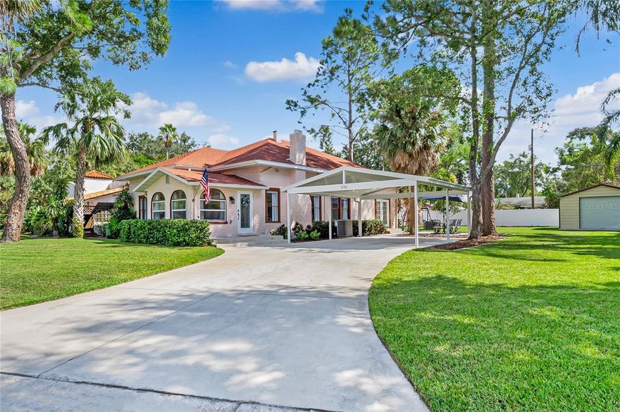 Mediterranean Revival residence blends historic architecture with modern updates, creating a rare offering in the heart of Winter Haven. Just across from Lake Cannon and near Lake Mirror on the scenic Winter Haven Chain of Lakes, this home embraces the character of a Spanish bungalow while offering the comfort and livability of thoughtful renovation. The neighborhood itself is steeped in charm, with beautifully maintained older homes, tree-lined streets, and refreshing lake breezes that make evening strolls especially enjoyable as you take in the architecture and picturesque water views. Curb appeal is undeniable with a textured stucco exterior, arched windows, and an oversized double lot shaded by mature trees and old Florida palms. A covered two-car carport, new concrete driveway, and professional landscaping with St. Augustine sod and irrigation set the tone for what awaits inside. Upon entry, the formal living room greets you with Saltillo tile floors, a beadboard ceiling, and arched windows framing the lush front yard. Nearby, the family room provides a warm retreat with a coved ceiling, original hardwood floors, and a gas-burning brick fireplace that invites both quiet evenings and lively gatherings. Tucked discreetly off this space, a computer nook offers a dedicated corner for work or study. The formal dining room is rich with historic detail, showcasing softly curved ceilings, arched transitions, and corner built-in cabinets with glass doors. In the kitchen, past and present meet seamlessly with wood cabinetry, soft-close drawers, granite countertops, stainless steel appliances, and a walk-in pantry with laundry connections. Three bedrooms and two baths complete the interior, including a primary suite with French doors that open directly onto the patio, extending the living space outdoors. Both bathrooms have been tastefully remodeled with marble, porcelain, and ceramic tile, new vanities, and updated fixtures, maintaining period charm while providing modern comfort. The outdoor areas are just as appealing, with a rear patio overlooking a private backyard ideal for entertaining, gardening or relaxing. For hobbies or storage, a detached 18x19 workshop with roll-up door, electricity, and concrete slab is well suited to woodworking, automotive projects, or boat storage. Extensive updating gives peace of mind: a new roof with 30-year shingles, updated plumbing and electrical systems, new HVAC units with ductwork, refinished hardwood floors, replastered and retextured walls, remodeled kitchen and baths, and fresh interior and exterior paint. Additional improvements include Tiffany-style fans and period lighting, and a newly installed well-fed sprinkler system. With city water and city sewer, the home is as functional as it is beautiful. Conveniently located minutes from downtown Winter Haven, shopping, dining, schools and medical facilities, and with easy access to the Polk Parkway for commutes to Lakeland, Tampa, or Orlando, the property also offers quick access to boat ramps on the Chain of Lakes for fishing, boating, and waterfront dining. For those who appreciate historic homes, Spanish bungalows, and Mediterranean Revival architecture, this home is a rare opportunity to own a lovingly restored residence where character and modern comfort come together seamlessly.