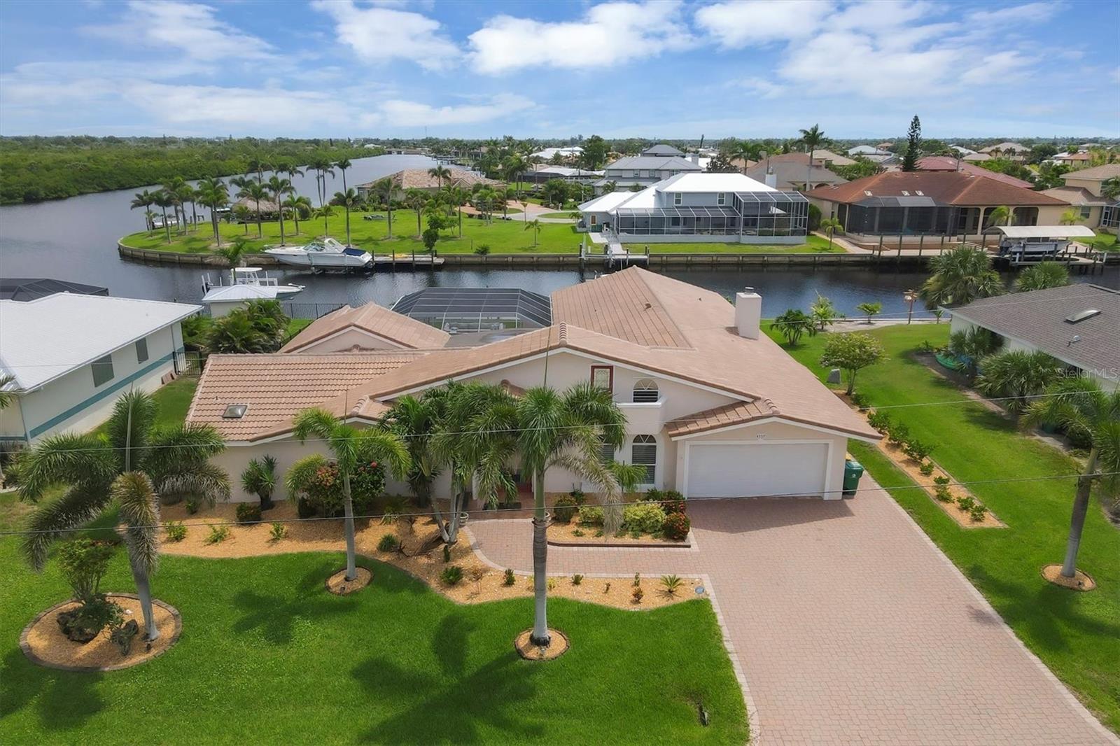 Experience the ultimate in waterfront living with this stunning 4-bedroom, 5-bath home located just minutes from Charlotte Harbor — with no bridges to open water. This spacious and well-designed home features a formal dining room, private den, family room, and a large sitting area off the master suite, ideal for a quiet retreat, office, or lounge space.
The heart of the home opens up to an expansive lanai that wraps around a resort-style pool, all enclosed by a brand-new pool cage. With four sets of French doors and sliders leading out to the pool area, the layout offers effortless indoor-outdoor living and entertaining. The newly landscaped grounds frame the water views, while a boat lift and two davits for jet skis make it easy to enjoy the waterfront lifestyle.
Upstairs, a loft at the front of the home provides flexible additional living space and features its own private balcony — perfect for a reading nook, home gym, or game room. Additional highlights include a new roof, dual-zone A/C, and direct sailboat water access with no bridges to the harbor.
This is a rare opportunity to own a true Florida waterfront retreat with generous space, thoughtful design, and unmatched boating access.