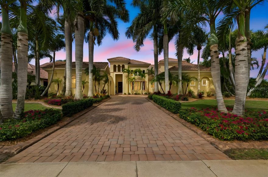 Welcome to a waterfront residence where thoughtful design, modern comfort, and timeless character come together in perfect harmony. From the moment you step inside, a soaring foyer draws your eye straight through the living room to the sparkling pool and the tranquil lagoon beyond, a breathtaking first impression that sets the tone for the entire home. Sunset views from the screened-in pool area are nothing short of spectacular. Inside, tall ceilings, custom finishes, and curated textures create a warm, inviting atmosphere that never feels cavernous despite the home’s generous scale. The wine closet, framed by a custom-carved wood detail over glass, pairs beautifully with the striking bar area featuring a mirror-mosaic wall treatment. The family room, kitchen, and eat-in space flow seamlessly together, anchored by an incredible barnwood feature wall with hidden storage, a 77" TV, and an LED fireplace. A woven bamboo ceiling and softly glazed walls add depth and sophistication. The chef’s kitchen is a dream workspace, equipped with Viking appliances, a gas cooktop, a pantry closet, a butler’s pantry, a prep sink, granite countertops, and abundant storage. A mica-accented ceiling inset adds a subtle glow. Nearby, the large laundry room offers a sink and additional storage. Three bedrooms are located on the main level, including the serene primary suite. Overlooking the pool and lagoon, it features a raised sitting area, a massive custom closet, and beautiful lighting. The spa-inspired primary bath includes a walk-in shower facing an outdoor water feature, dual vanities, a makeup area, and a private water closet. The second bedroom includes an ensuite bath and walk-in closet, while the third bedroom offers a large walk-in closet and peaceful water views.
The screened-in pool area features brick decking, a gas fireplace, and a fully equipped outdoor kitchen with a brand-new built-in gas grill, tile countertops, and ample storage. The 15,000-square-foot lot includes 100 feet along the lagoon — one of Mirabay’s premier waterfront addresses. A low-maintenance riprap shoreline and a wood dock with power and water make it easy to enjoy kayaking, canoeing, or simply watching the sunset. Upstairs, you’ll find a private fourth bedroom with a walk-in closet, a full bath, and a spacious multipurpose room ideal for a home theater, fitness studio, or game room. Hand-painted ceiling details, textured walls, and a balcony overlooking the water add charm and character. Recent updates include three new AC units (2024 and 2026). The exterior is equally impressive, with lush tropical landscaping, split garages (one-car and two-car), and a wide paver driveway perfect for guests. A custom vertical fountain near the entry sets a soothing tone before you even step inside. There are custom decorative finishes throughout the home. Control4 home automation (multi-room audio, home theater, HVAC, partial interior lighting, monitored security, video surveillance, garage door control) provides comfort, convenience, and peace of mind. Located within a private gated enclave inside Mirabay, residents enjoy world-class amenities: pickleball, tennis, and basketball courts; a resort-style pool; a community restaurant; gym and sauna; playgrounds; yoga, stretch, and Zumba classes; plus complimentary kayaks, sailboats, and paddleboards. You truly never have to leave. And when you do, you’re just 30 minutes from downtown Tampa or St. Pete, and under an hour to Sarasota.