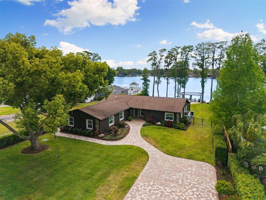 Welcome to 18520 Wayne Rd in Odessa, where lake living on Lake Keystone becomes your everyday reality. Set on a .57-acre lot with direct water access and western exposure for sunsets, this beautifully updated home offers the perfect blend of comfort, style, and the unmatched lifestyle that Lake Keystone is known for. Spanning approximately 434 acres, Lake Keystone is one of the area's most sought-after private ski lakes, ideal for boating, jet skiing, fishing, and sunset cruising, all within a peaceful, scenic setting just minutes from Tampa. Enjoy the freedom and flexibility of lakefront living with NO HOA and NO CDD. Featuring 4 bedrooms, 3 full bathrooms, and nearly 3,000 sq ft, this home offers an open floor plan designed for both everyday living and entertaining. The garage was redesigned to include a bedroom, full bathroom, living room, and separate entrance, making it a perfect space for an in-law suite or guest suite. Thoughtfully updated throughout, the home shows like new with a fresh, warm, and inviting feel. The kitchen, remodeled in 2017, showcases granite countertops, Whirlpool Gold appliances, and flows seamlessly into the main living spaces for a bright and welcoming atmosphere. Inside, the home offers a crisp, cohesive aesthetic with plantation shutters, updated finishes, and expansive double-pane windows (replaced in 2020) that frame serene lake views. The spacious primary suite has been thoughtfully remodeled and provides a peaceful retreat overlooking the water, while a private guest suite offers comfort and flexibility for visitors. Step through the rear French doors and the lake immediately becomes your backdrop. A beautifully designed paver walkway leads you through the lush backyard to your private covered dock, creating a seamless transition from indoor living to the outdoors. Along the way, multiple seating areas offer the perfect setting to relax, entertain, and take in the views of the property's 84 feet of lake frontage. The covered dock sits on the lake and is ideal for boating, jet skiing, fishing, or simply unwinding as the sun sets over the water. From morning coffee by the water to evenings spent on the dock, this home is designed to fully embrace the Lake Keystone lifestyle. Recent updates and improvements include: remodeled kitchen in 2017, double-pane windows replaced in 2020, primary suite remodel, guest suite enhancements, remodeled laundry room, updated bathroom, new exterior doors in 2021, new landscaping in 2023, paver driveway and walkway, and fresh exterior paint completed in 2025. Located just 15 to 20 minutes from downtown Tampa, you'll enjoy easy access to top dining, shopping, and entertainment while still coming home to a quiet, private waterfront setting. Discover lakefront living with space to relax, entertain, and be on the water whenever you choose. Homes like this on Lake Keystone do not come around often — a rare combination of location, thoughtful updates, and direct water access.