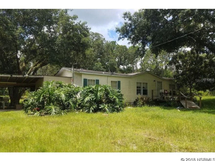 SECLUDED SANCTUARY! If you enjoy nature, hunting, 4 wheeling and lots of privacy, this is the place for you. Could be a great snow bird get away from the bitter cold of the North or your year round hideaway....Home sits on a total of 3 3/4 acres and offers both front and back ramps for easy access. There is a septic, well, low power bill and dish services the area for your TV and Internet needs. You can make it your own with a little TLC. The home also offers inside laundry, covered carport/workshop area and screened back porch. Close to New Smyrna Speedway, Walmart, I-95 and Beaches.