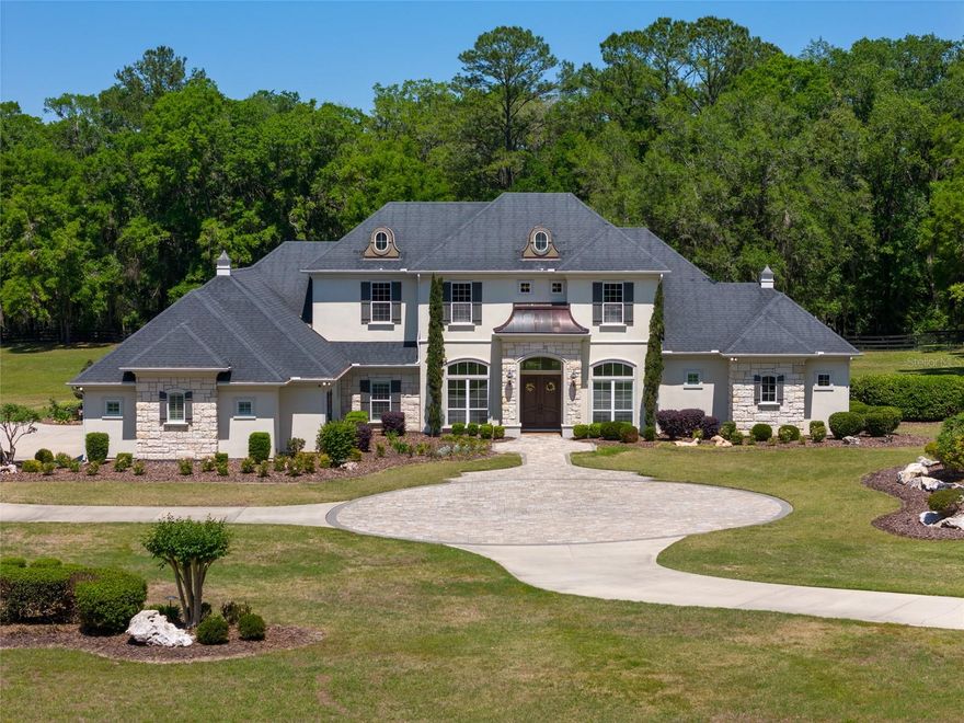 Welcome to this stunning luxury home in the exclusive, gated community of Wyndsong. Built by Tommy Waters and sitting on 5 beautifully landscaped acres, this custom residence features high ceilings, extensive built-ins, and an open-concept layout that seamlessly blends everyday living with high-end entertaining.

The kitchen offers two walk-in pantries, premium appliances, and a large island that overlooks the living area, complete with custom finishes and in-ceiling speakers for music or surround sound. Just beyond the living space, the game room is an entertainer’s dream, featuring a wine storage and wet bar. A dedicated home office with built-in cabinetry and desk provides a stylish and organized workspace.

Upstairs, you’ll find a spacious loft that connects two bedrooms with a Jack and Jill bathroom, plus a climate-controlled flex/storage room that can easily be transformed into a studio, office, bedroom, or more.

Step outside to a saltwater pool and hot tub, paired with a summer kitchen and bar, perfect for hosting. Toward the back of the property, a fire pit creates a cozy space for gatherings on cooler nights.

Additional upgrades include an oversized 4-car garage, two zoned HVAC systems, and a whole-home Generac generator for peace of mind during hurricane season. The home is also has excellent insulation in 2 attic spaces and to keep the house cool in the summer, along with 4 gas fireplaces placed throughout the house for the chilly winter days.

The Wyndsong community offers peaceful walking and horseback riding trails, adding to the lifestyle appeal.

This rare property combines privacy, space, and luxury. Come see for yourself!