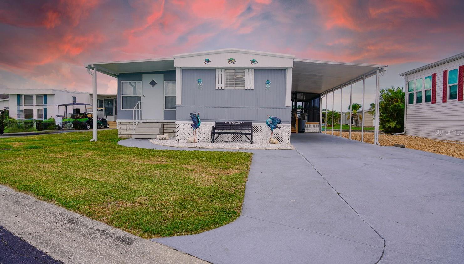 Welcome to waterfront living in the highly sought-after 55+ gated community of Caribbean Isles! This meticulously maintained 2 bed, 1.5 bath, 1 carport (2 Spaces) home offers 998 square feet of comfort and upgrades throughout. Enjoy peace of mind with a new roof (2022), new 3.5-ton HVAC with ductwork (2025). The home also features a new shower (2023), updated flooring, doors, and windows in the Florida room, perfect as a sunny bonus space or playroom for the grandkids. Boaters will love the new 13,000 lb boat lift with metal roof (2024), offering easy access with just a 25-minute idle-speed ride to Tampa Bay. Relax outdoors with a 10x20 screened-in deck overlooking the water, or entertain at your very own tiki bar with pavers (2023). Fresh exterior paint (2025) gives the home a crisp, updated look. Plenty of boat and trailer storage is available for just $120/year, and community amenities include 3 secure entry gates, a heated pool, boat ramp, clubhouse, library, and vibrant social calendar. Monthly HOA is just $242. Whether you're a seasonal snowbird or full-time Florida dreamer, this home offers it all.