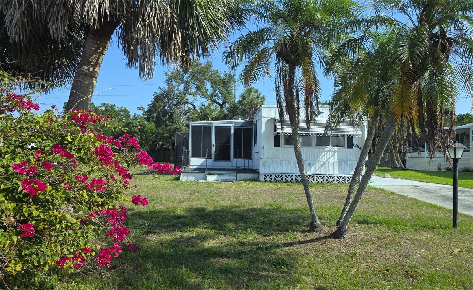 Are you an Investor or someone looking to make a home of your very own? This is an opportunity for you to come and make the necessary upgrades and personal touches to make this your home in the sought after 55+ Community of Holiday Mobile Home Estates. This home is situated on a cul de sac with an oversized lot and a Pool under a screened Lanai. There are no neighbors behind the 0.263 lot giving you peace and quiet while watching the birds and the amazing sunsets sitting poolside. The screened porch at the entrance to the home provides a lovely place to sit and have your morning coffee. The utility room has ample place for storage and laundry while the driveway offers ample parking where the carport can be easily replaced. The roof has no leaks and the windows are fully intact. The kitchen has great potential. Pick your flooring and make this your private retreat. The HOA is low with an option to be a part of the Edgewater Club at a low additional cost. The Club offers pool amenities, athletic activities, a clubhouse and many social gatherings. This Golf Cart Community is close to shopping, Beaches and many outstanding Restaurants. This home needs to have some great vision and love to find its new owners that will be part of this outstanding cohesive community.