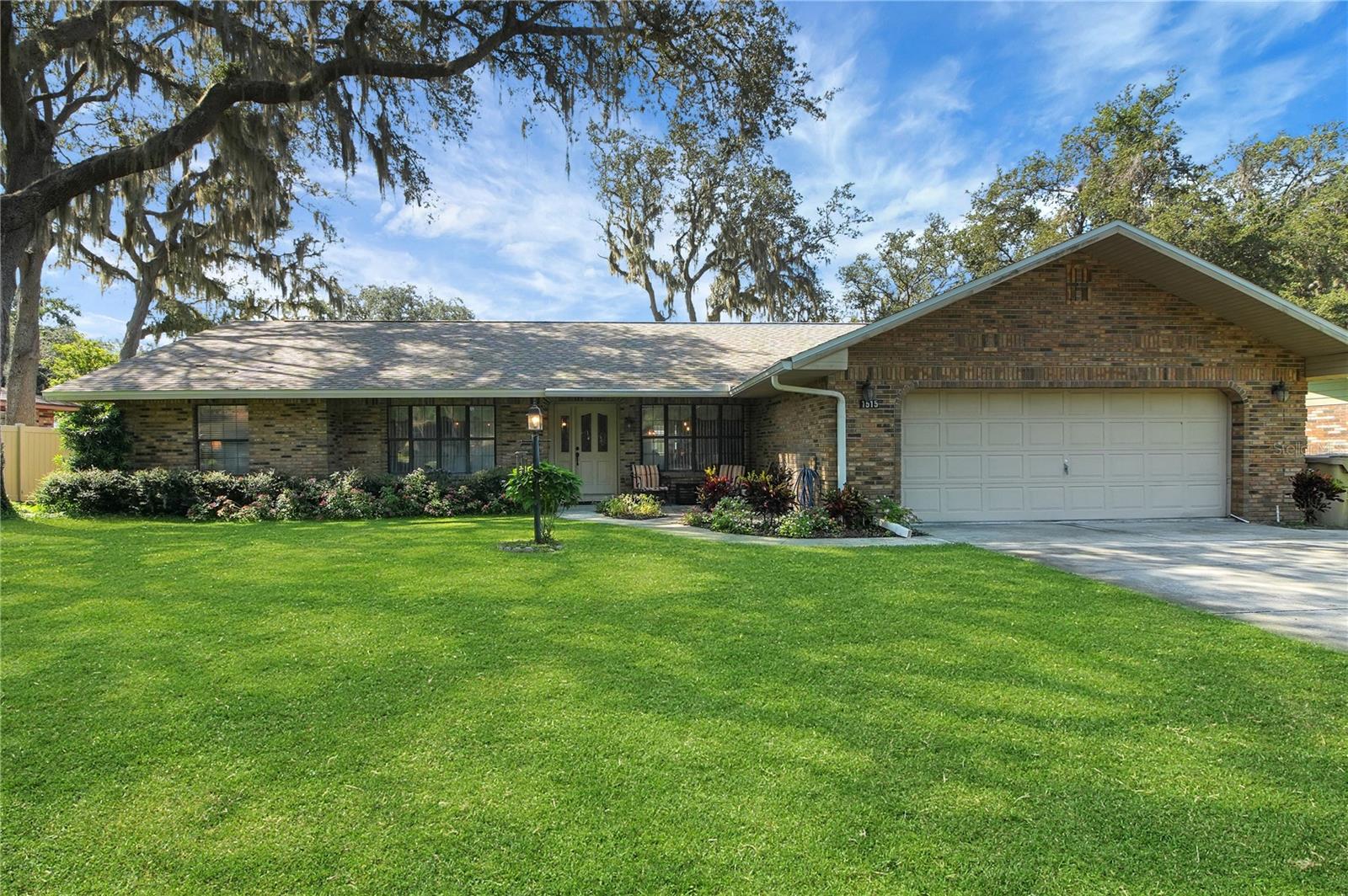 Lovely 2500+ sq ft heated BRICK home with WORKSHOP (14 x 18) in a well established neighborhood on .34 acre lot conveniently located where you can access at least 7 cities plus the turnpike within 30 minutes drive. Some features include a NEW Architectural shingle ROOF 2023, New HVAC 2024 and newer water heaters. This home is surrounded by Spanish moss oak trees not only providing beauty but also plenty of shade. This home is sure to please with 3 bedrooms, 2 bathrooms, a formal dining room, a family room, a spacious living room, a large kitchen, an inside laundry room plus a Florida room. This split bedroom floor plan boasts a beautiful wood burning fireplace, high ceilings, 5 skylights, bay windows, French doors, ceiling fans and wooden baseboards and trim throughout. The kitchen has tons of cabinetry and counter space, a pantry, stainless steel appliances plus an eat in area. The spacious master suite (16X16) has a walk-in closet plus an additional full sized closet and 2 windows letting in plenty of light. The en-suite has dual sinks, a skylight and a walk-in shower. There is an oversized 2 car garage and pull down attic stairs for your extra storage needs. Out front, there is a beautiful paver patio with freshly planted flowers lining it. In the back there is a screened lanai, an additional patio area outside plus a WORKSHOP with ELECTRICITY and a WINDOW UNIT installed for your comfort. Conveniently located close to shopping, restaurants, medical offices and The Villages! **Seller is offering $5,000 towards buyer's closing costs or cosmetic upgrades.