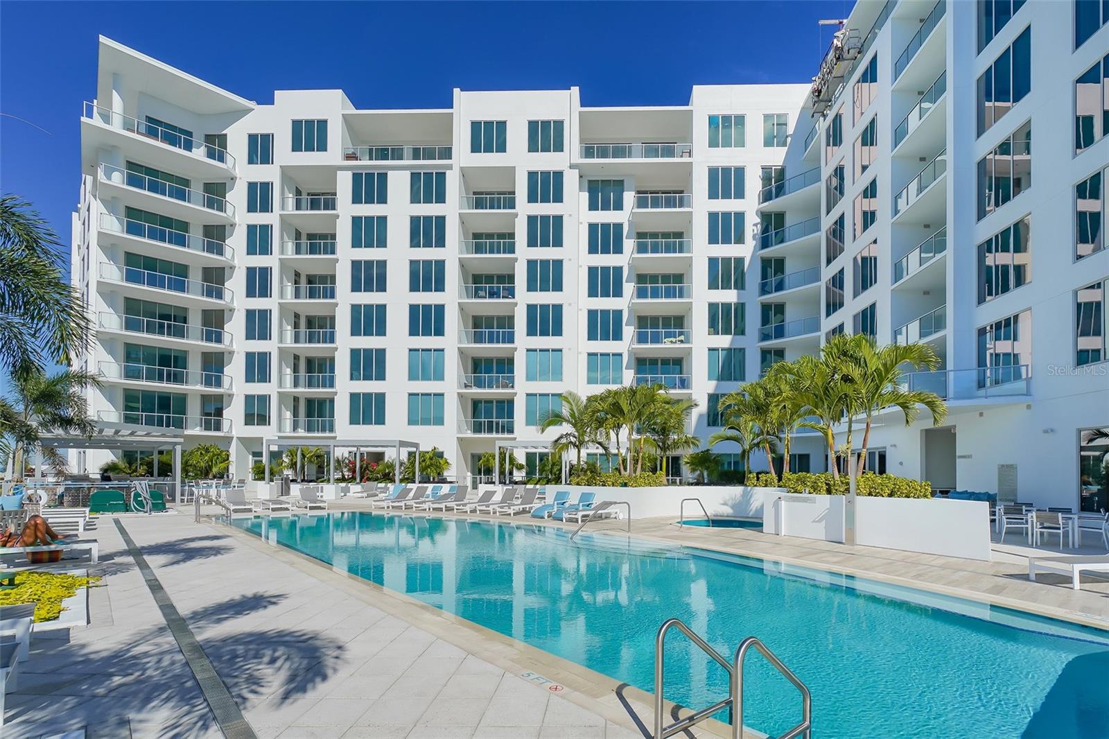 One or more photo(s) has been virtually staged. Experience modern and stylish living at The Mark in this beautiful 2 bedroom, 2.5 bath plus den unfurnished condo available for annual lease. The location in downtown Sarasota is steps away from shops, restaurants, Whole Foods, theaters, and the waterfront, with easy access to the airport and beaches. This elegant unit features porcelain plank floors, a gourmet kitchen with European cabinetry, Calacatta quartz counters, Jenn-Air stainless steel appliances, including an induction stovetop and wine chiller, and a chic island with bronze pendant lighting. Enjoy pool and partial bay views through floor-to-ceiling windows with automated shades. The primary suite offers a private balcony, 10-foot ceilings, custom walk-in closets, and a luxurious bathroom with a white oak vanity, dual sinks, and a tiled shower. A guest bedroom with en-suite bath and a versatile den with a Murphy bed complete the layout. Includes two parking spaces and a climate-controlled storage unit. Residents benefit from 24 hour concierge support, a secure entry lobby, and exceptional community facilities on the fifth-floor deck, including a 65-foot heated saltwater infinity pool with jacuzzi, relaxation zones, a cozy fire pit, barbecue areas, a state-of-the-art gym with spin studio, and a social lounge equipped with a fireplace, bar, pool table, full catering kitchen, and media room.