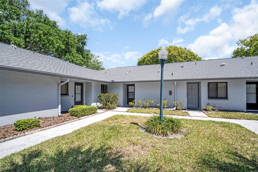 LOCATION.TURNKEY. MAINTENANCE FREE. Tucked away in the heart of Countryside, this beautifully maintained 2-bedroom, 2-bath villa offers the perfect blend of style, comfort, and low-maintenance living. From the moment you arrive, pride of ownership shines through every detail—making this home truly move-in ready. Step inside to discover an upgraded kitchen, complete with wood cabinetry, gleaming quartz countertops, and updated appliances. The open-concept layout flows seamlessly into the spacious living room and dining room. Enjoy morning coffee or evening relaxation in the dining area, where sliding glass doors open to a fully enclosed lanai—ideal for year-round enjoyment. With no rear neighbors, you’ll appreciate the peace and privacy this villa offers. The primary suite is your private retreat, featuring an upgraded ensuite bath and plenty of closet space. A versatile second bedroom, can easily serve as a home office or guest bedroom with its own adjoining bath—perfect for visitors or working from home. With one assigned parking space, you’ll always come home with ease.  Additionally, the pool is seasonally heated. And the location? Unbeatable. You’re only minutes from Countryside Mall, Tampa, St. Pete, the Clearwater Library, recreation centers, top restaurants, and just a short drive to Dunedin’s beaches and ballpark. All that’s left to do is move in and start enjoying the Florida lifestyle you’ve been dreaming of! This home has all newer 4 point items as well, from the roof to the HVAC to the water heater. This home is move in ready!