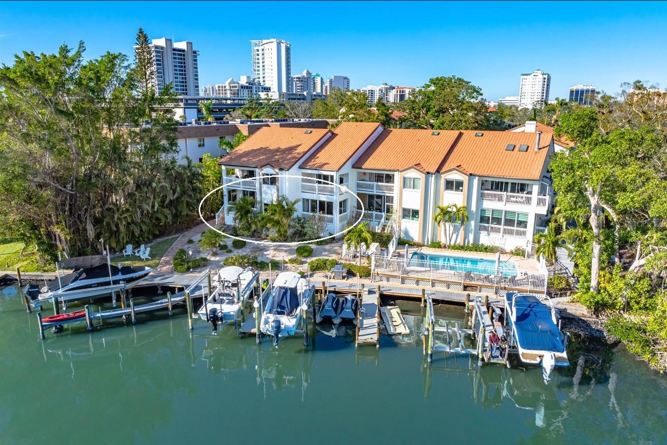 Waterfront double unit in Hudson Landings: Two residences have been combined into one creating this expansive 3 bedroom, 3 bath and 1 office/den home with large open living spaces, a deeded dock, 2 car garage plus 2 assigned parking spaces. This home features a well-appointed kitchen showcasing granite countertops and top of the line stainless appliances, a dry bar, crown molding, high ceilings with wood inlay and an Italian walk-in shower. Enjoy exceptional water and pool views from the master bedroom providing plenty of custom closet space. Take in the amazing water view from your patio with southern exposure while enjoying your morning coffee or a beautiful sunset from your private dock. Access your boat dock and the outdoor grilling area straight from your patio. This large, 2,300 sqft, single level corner unit is an incredible opportunity to live downtown overlooking the Hudson Bayou. The location offers a unique lifestyle and is walkable to Marie Selby Botanical Gardens and the beautiful Sarasota Bayfront and Marina. Hudson Landings is a best kept secret in Sarasota, with 12 residences tucked into a private, calm, and secluded location. Bring your boat and live downtown.