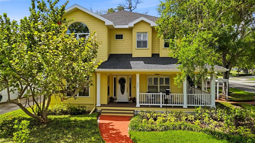 Welcome to one of South Tampa’s most iconic streets, where location and lifestyle come together seamlessly. Just moments from Tampa Bay Yacht Club, Ballast Point Park, and the entrance to the Bayshore Boulevard Fitness Trail, this residence also enjoys the rare convenience of being only one block from A-rated Ballast Point Elementary School. Rich in character and history, the surrounding neighborhood even carries ties to the legendary author Jules Verne—an added layer of charm for those who appreciate a story behind the setting.

A welcoming wraparound front porch sets the tone, delivering timeless curb appeal with a modern farmhouse aesthetic. Through the leaded glass front door, a spacious front-facing office with glass-pane double sliders offers a bright and refined work-from-home environment. Inside, newly installed luxury vinyl plank flooring flows throughout the main living areas, combining durability with a clean, contemporary feel. The kitchen is thoughtfully designed for both everyday living and entertaining, featuring abundant cabinetry with soft-close doors and drawers, convenient pull-outs, granite countertops, a tile backsplash, and 42-inch upper cabinets that maximize storage and visual height.

The open-concept layout allows the kitchen to transition effortlessly into a generously sized dining area, easily accommodating large gatherings with seating for up to ten. French doors with sidelights draw in natural light and create a seamless connection to the rear screened entertainment deck, where translucent polycarbonate panels allow sunlight to pour in while keeping the space protected from rain—extending usability year-round. The true centerpiece of the home is the grand family room, where soaring 25-foot ceilings and three tiers of oversized windows frame breathtaking views of Ballast Point’s signature oak canopy, creating a light-filled space that feels both expansive and connected to nature.

Upstairs, the primary suite is privately tucked away behind French doors, offering a peaceful retreat complete with a spacious walk-in closet with custom built-ins and a well-appointed bathroom featuring dual vanities, a soaking tub, and a separate shower. Two additional bedrooms provide flexibility for family or guests, one enhanced with charming window seats and the other showcasing a cathedral ceiling, both sharing access to an updated hall bath.

Outdoor living continues to impress with a large covered and screened party deck that connects effortlessly to the main living areas, ideal for entertaining or relaxing in comfort. A side-entry driveway leads to a detached two-car garage with overhead storage and convenient access to the covered rear lanai. The home’s exterior is wrapped in durable James Hardie fiber cement siding, offering long-term resilience with the aesthetic appeal of a modern farmhouse. The expansive front and side yards present endless opportunities to create a private outdoor oasis, whether envisioned as a garden, play area, or alfresco dining retreat.

Recent updates, including a 2020 shingle roof, 2021 gutters and kitchen cabinetry, 2021 LVP flooring, a 2023 vinyl fence, and a 2023 HVAC system, provide peace of mind and enhance the home’s overall value. Positioned at a high elevation with no history of flooding, this property offers both beauty and confidence in its construction and location. This is a rare opportunity to own an updated home in one of South Tampa’s most sought-after neighborhoods.