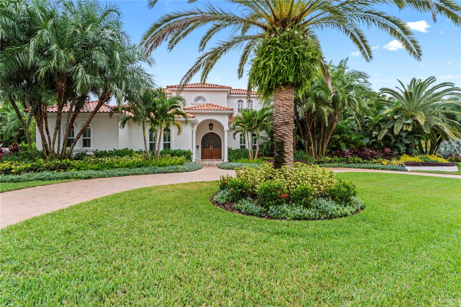 Curb appeal galore with this perfectly landscaped home situated on a unique corner lot in the sought after neighborhood of Beach Park in South Tampa with a hard to find FIRST FLOOR MASTER BEDROOM SUITE. Step into the home to the inviting formal living room and dining room which both overlook the tranquil and very private lushly landscaped pool area. The eat-in kitchen opens to the family room with fireplace and full wet bar with custom built-ins. The kitchen features granite countertops, newer appliances, a double oven, and an induction range (although wired for gas if you prefer). There are 3 outdoor entertaining/relaxation areas including the pool area, a back deck located off the kitchen where you can find your gas wired grill, and a cozy screened in porch off the family room. The primary bedroom is located on the first floor as well as the 4th bedroom which is being used as an additional master closet space but can be easily converted back to a bedroom or first floor office if needed. Upstairs are 2 more bedrooms PLUS a home theater with stadium seating. The 3 CAR GARAGE is located on the side of the home and is air conditioned! Truly a fabulous home not to be missed! **See Attached Virtual Tour with Floorplan**