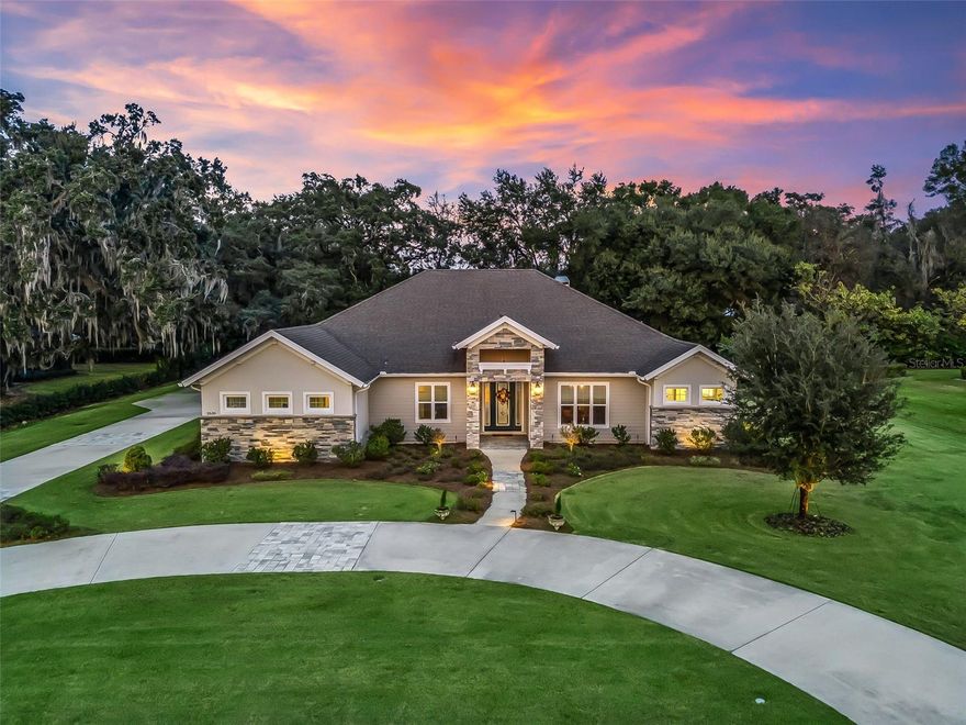 Quality, comfort, and thoughtful design define this exceptional residence in the gated community of Legendary Trails in Southeast Ocala. A circular driveway sets the tone with stately curb appeal, stone accents, and a large glass front door with sidelights, with the drive extending to the oversized 4-car garage tucked privately in the back of the home. Once inside, you are welcomed by high-end finishes & a view directly to the outdoor oasis & centered waterfall spa beyond the pocketing sliding glass door. Rich hardwood flooring flows through the main areas & is complemented by detailed millwork including crown molding, paneled archways, & a coffered ceiling in the living room. The open kitchen features stone countertops, abundant cabinetry & storage (incl. storage behind the breakfast bar), upper display cabinets with lighting, tiled backsplash, & a suite of stainless appliances including a five-burner gas cooktop, built-in smart convection oven, & wine cooler. Adjacent is a large scullery/butlers pantry with additional full-size refrigerator, sink with disposal, & cabinetry. The luxurious primary suite overlooks the pool & includes an ensuite bathroom with extensive cabinetry, dual vanities, & heated floors, including the shower which boasts three heads. Two walk-in closets include custom built-ins, & the larger closet includes a stackable washer & dryer. This triple-split floor plan provides privacy for the whole family & guests: two bedrooms share a full bath, while a fourth bedroom sits adjacent to another full bath that doubles as a pool bath. All closets include built-in systems, & multiple linen closets add further storage. The outdoor living space is reminiscent of a private resort. The expansive north-facing covered lanai features a stone wood-burning fireplace with gas starter & a fully equipped outdoor kitchen, flowing to the screened pool deck finished with pavers & artificial turf. The heated, saltwater, volleyball-style pool is surrounded by marble & includes a large 8-person elevated waterfall spa, deck water fountains & lighting. The oversized 4-car garage provides walkable attic storage above, smart jackshaft openers with high-lift tracks, epoxy floor, & French doors from the 4th bay to the pool deck. A whole-home standby generator offers peace of mind & is powered by the 1,000-gallon buried propane tank. Additional features include: smart-home automation, interior & exterior surround sound, outdoor landscape lighting throughout the property, a wired security system, 8-camera surveillance, plantation shutters & shades, heated towel racks in every bathroom, ambient crown-molding lighting, occupancy-sensor lighting, keyless entry, and other refined details throughout offering the utmost in comfort & function - detailed feature list available. Legendary Trails provides a fantastic Southeast Ocala location less than 1 mile to the Santos Trailhead & under 2 miles to The Country Club of Ocala, plus convenient access to Belleview & The Villages to the South. Please enjoy the attached video & 3D tours, & schedule your private showing before it's too late!