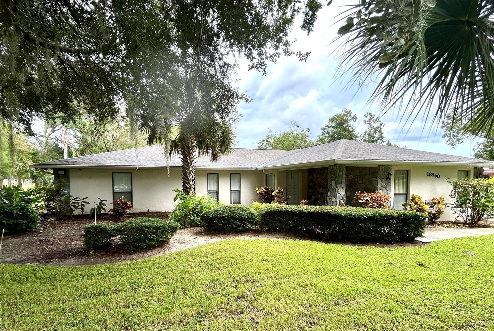 ** LAKE ACCESS ** ASSUMABLE LOW INTEREST RATE MORTGAGE ** NO HOA ** Looking for the perfect place to live life on your own terms? Look no further: No HOA! Private neighborhood Boat Dock! Almost an acre of land - so you can park your Boat and RV without being harassed. You’ll have the best of both worlds, with a large lot in a quiet, established neighborhood, yet still close to Orlando, Clermont, and all that Central Florida offers. Upon entering, you will enjoy an Open Floor Plan, with an oversized Family Room / Dining Room combo, a Wood Burning Fireplace and vaulted ceilings, providing a great place to gather plenty of family and friends! The kitchen has a bar that opens to the Family Room, creating a great flow, so that everyone is connected and can visit easily. The kitchen offers stainless steel appliances, has a built-in oven, and cooktop, and lovely French Doors that take you to your huge back patio, currently screened in, with the option of closing it in (windows on-site.) Split Bedroom plan, with Oversized Primary Bedroom on one side with en-suite bathroom with separate tub and shower, and two more bedrooms on the other side with the second bath in between. Inside Laundry Room conveniently located in the large primary bedroom closet. Established, friendly, smaller neighborhood, with a private boat ramp, just for the neighborhood's use. This is a place where neighbors actually get to know one another, and are there when you need them. The hard-wired security system comes with the house, featuring 16 exterior view cameras that you can monitor from inside (see photos). There is also storage shed out back for lawn equipment, etc. Beautifully landscaped with lush lawn, oaks, palms, crepe myrtles and more, for that perfect Florida feel. Come see your forever home today, leave the HOA behind, and enjoy your property the way you should be able to! Priced to Sell!
