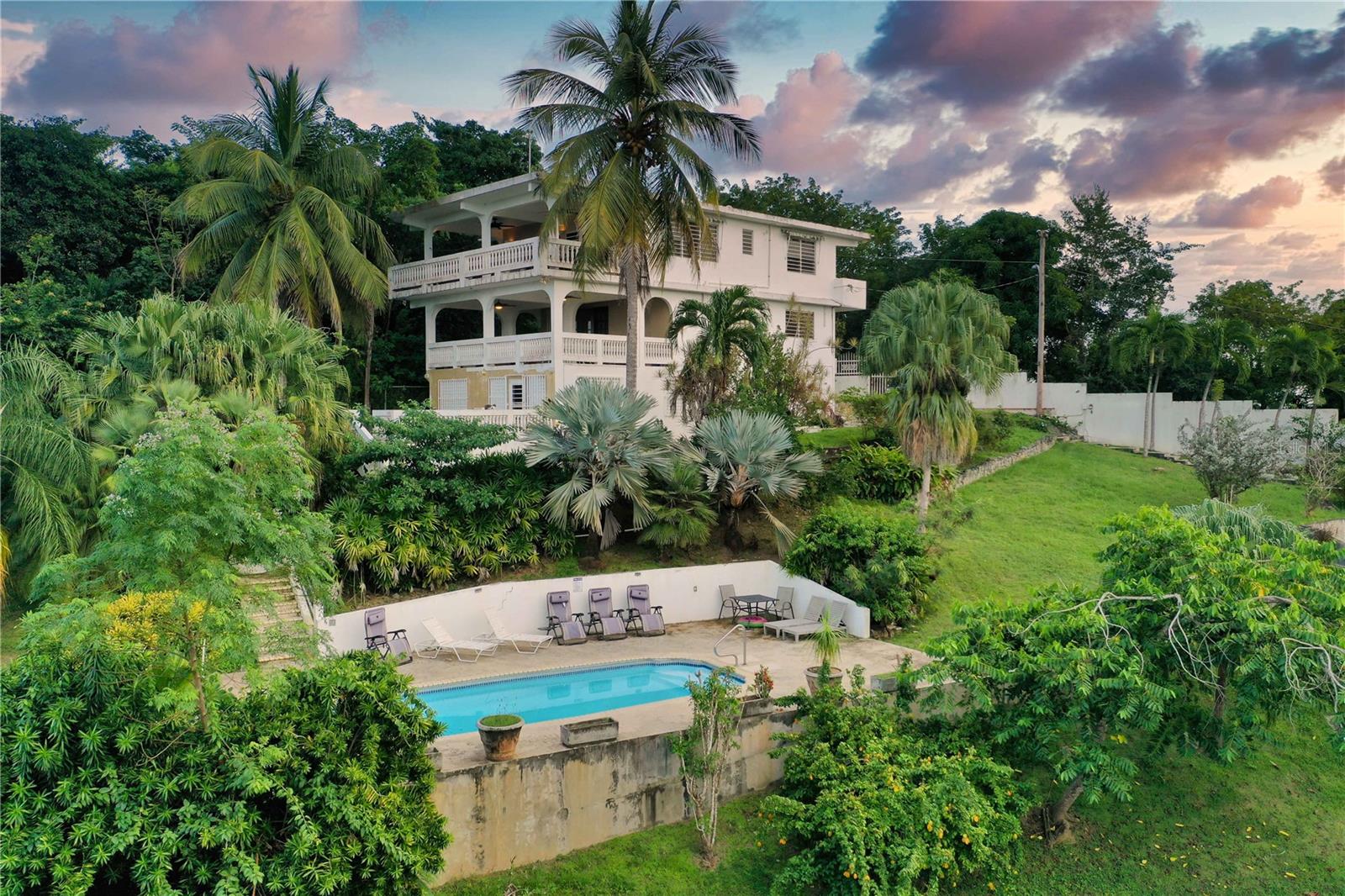 Welcome to Casa Anonna, situated in the Monte Santo neighborhood. Casa Anonna offers the perfect blend of privacy and accessibility. Its central location places you just minutes from the vibrant towns of Esperanza and Isabel Segunda, known for their dining, shopping, and nightlife. Whether you’re heading to one of Vieques’ world-renowned beaches or enjoying the island’s unique attractions, such as the mesmerizing Bioluminescent Bay, you’ll find everything within easy reach.
The property is set on over half an acre of walled and gated land. The tropical garden, filled with avocado, banana, papaya, coconut, mango, and tamarind trees, creates a lush oasis. Birds of Paradise and other vibrant plants add to the natural beauty. Central to the property is a large private swimming pool, complete with lounge chairs—the perfect spot for relaxing in the sun or catching sight of a playful iguana.
Casa Anonna’s layout is thoughtfully designed with three separate units, each offering its own private entrance. Whether you’re searching for a Vieques vacation home, a full-time residence, or an investment property, the flexibility of these units makes this an ideal option. Here’s a closer look at what each level offers:
Top Floor: This spacious unit includes two bedrooms, two full bathrooms (one ensuite), and a large living room. French doors lead to the private veranda off of the kitchen and living room, as well as a balcony off the primary bedroom, offering even more opportunities to enjoy the views. The kitchen features tiled floors, an island, and modern appliances, including a dishwasher and stove. A washer and dryer are conveniently located in the hallway closet. This level offers ample space for family living or entertaining.
Middle Level : This two-bedroom, one-bath unit features a dine-in kitchen, a cozy living room, and a private veranda with stunning views of Vieques and the Caribbean Sea. Ceiling fans and louvered windows enhance the tropical breezes, and air conditioning in each bedroom ensures restful nights. The kitchen is fully equipped with a stove, refrigerator, and dishwasher, making it perfect for everyday living or entertaining guests.
Bottom Floor: Currently serving as the property manager’s residence, this unit includes one bedroom, one bathroom, a combined kitchen and living room, a laundry room, and two storage rooms. This space could easily be converted to suit your needs, whether as an additional rental unit or private quarters.
Vieques properties are sought after for their natural beauty, relaxed pace, and investment potential. Casa Anonna’s history as a successful rental property makes it a turnkey option for anyone looking to invest in Vieques real estate for sale. The property’s concrete construction and thoughtful design ensure durability and comfort, while the expansive grounds provide room for additional structures or amenities. Whether you’re considering adding casitas, recreational areas, or simply enjoying the property as it is, the possibilities are endless.
Whether you’re seeking a Vieques vacation home, an investment property, or a full-time residence, Casa Anonna is a rare opportunity to own a piece of Vieques Island, Puerto Rico real estate. With its stunning views, private pool, and flexible living spaces, this property embodies the best of Caribbean life.