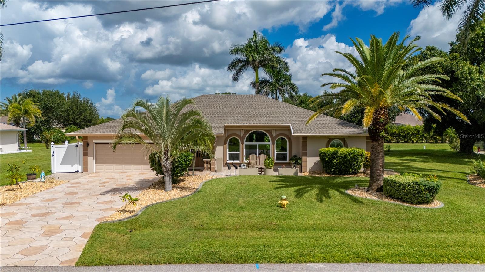 Some homes have rooms. This one has destinations-a kitchen built for feasts, a patio made for sunsets, and a pool area that turns ordinary weekends into mini-vacations. Spread across nearly half an acre of landscaped beauty with peaceful greenbelt views, this Deep Creek gem blends warmth, elegance, and over $200,000 in thoughtful upgrades. Step inside through double entry doors to a light-filled living space with an electric fireplace and easy flow to the dining area. Beautiful plank tile flooring and soaring ceilings to 12 ft in height enhance the overall living space throughout home. The entertaining focal point is the 2023 kitchen remodel-with high-end GE Café appliances, solid wood cabinetry, quartz counters, a farmhouse sink and 5’x10’ custom pantry. The pristine gas cooktop and convection double oven with air fryer capabilities make every meal an occasion. From the kitchen, gather in the family room with adjacent custom wet bar with wine fridge service, or open the sliders to the screened lanai and pristine waters of the resurfaced pool. The split-bedroom layout offers privacy for the owner’s suite, complete with dual walk-in closets and a spa-like bath, while guests enjoy their own wing with pool access. Step outside to the open air lanai complete with pergola, wood-fire pizza oven and Breeo smokeless fire pit. Upgrades such as hurricane-impact windows and doors (2023), tankless gas water heater, Halo whole-house water treatment (2023), replumbed plumbing and fresh 2023 paint inside and out ensure comfort and efficiency for years to come. All just minutes from I-75, golf courses, shopping, dining, historic Punta Gorda, Fishermen’s Village, and Punta Gorda Airport.