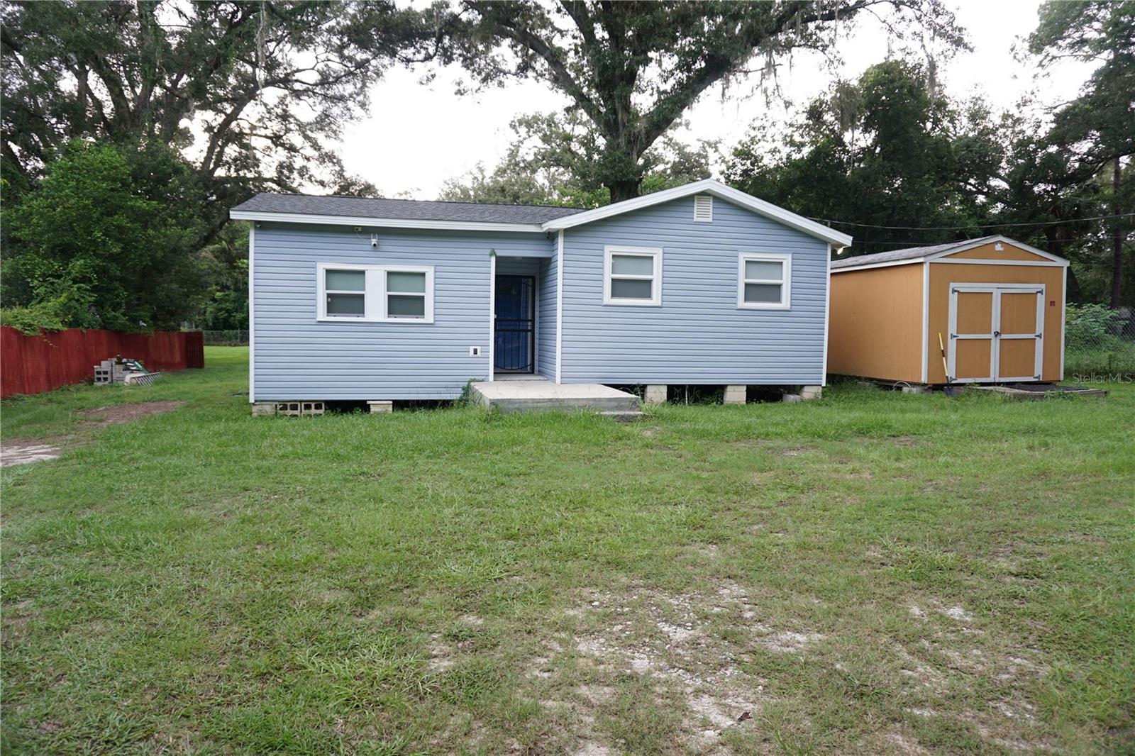 Nicely remodeled 2/2 is on a fenced .27 of an acre lot with 6' fence and an additional .39 that can be purchased. This home has a new Architectural Roof in 2025 and a nice 12' x 24' pre-fab shed anchored to the ground. Everything inside and out has been updated including AC, water heater & new electric panels inside and out. Nice insulated vinyl frame windows and newer vinyl siding. The kitchen cabinets, counters, fixtures and Stainless Steel and black appliances are new, includes front load washer & dryer also. Built in storage and coffee nook for extra storage. Nice size living room with dining area and nice furniture included. The ceilings and walls have been updated with tongue and groove wood panels, new doors, trim, hardware and new flooring through out home. Both bathrooms are remodeled with one having a tile shower and the other is a tub/shower combo. The furniture is all included with wall mounted TV's in 3 rooms, sofa, matching chair, dining table w/ two chairs, full size bed, bunk beds, dresser, lounger small tables, lamp, etc. All equipped and ready to move in. Extra .39 of an acre fenced lot with power pole and septic tank available for $35,900.