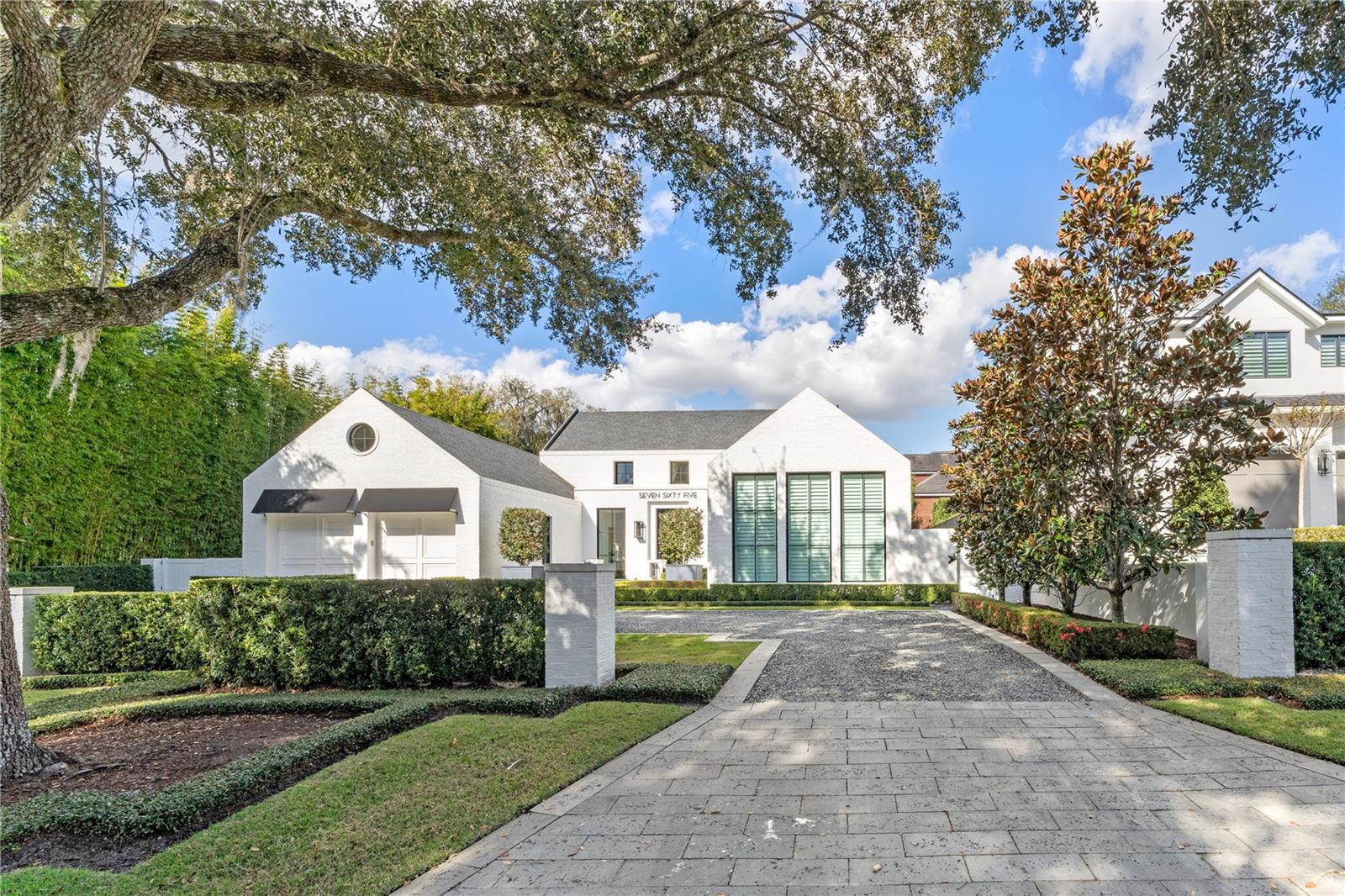 A true architectural gem in the heart of the Vias, this one-of-a-kind modern, custom residence masterfully crafted in 2019 by renowned builder Z Properties, Inc. Rarely does a “single-story” home of this caliber and scale become available combined with being located on one of the best addresses in all of Winter Park! Offering nearly 4,900 square feet of refined living space under air (which includes a noteworthy 551sf lanai, fully finished & separate zone air-conditioning) encompassing over 5,400 square feet total under roof... all tastefully designed with an emphasis on clean lines, organic textures, and exceptional indoor-outdoor flow... Beyond its striking curb appeal, the home opens to reveal expansive living spaces grounded by wide-plank hardwood floors and bathed in natural light from soaring cathedral ceilings and oversized windows. A seamless open layout connects the living and dining areas with a central gathering area anchored by a sleek linear gas fireplace. Award winning chef desinged kitchen is framed by a dramatic wall of glass and features premium Wolf and Sub-Zero appliances, including an 8-burner gas cooktop, integrated refrigerator, dbl built-in ovens, Miele coffee system, warming drawer, Scotsman ice maker, high level custom cabinetry and more... flanked by dual wine columns. The primary retreat is privately situated in its own wing, complete with a 20-by-10-foot custom walk-in closet and a spa-inspired bath with a soaking tub and oversized walk-in shower featuring multiple shower heads. The home's most captivating element is the fully enclosed, air-conditioned 29-by-17-foot lanai—accessible through disappearing glass doors that create a seamless transition from indoors to out. This sophisticated outdoor living space includes a full summer kitchen, al fresco dining area, lounge with gas fireplace, and motorized screens for further flexible utilization... Just beyond, a heated lap pool is framed by lush bamboo landscaping, creating a serene and secluded outdoor living environment... Another special feature is a secluded casita with offering an ideal space for guests or multigenerational living. Two additional ensuite bedrooms, each with walk-in closets, complete the 3-way split flexible bedroom layout along with a well-appointed utility/mud room entry off of the oversized two-car garage… Ideally located near the Winter Park Racquet Club, Interlachen Country Club, and walkable to Park Avenue, this exceptional residence also offers an extraordinary blend of modern design, luxurious functionality, and premier location… Truly, Winter Park living at its finest!!