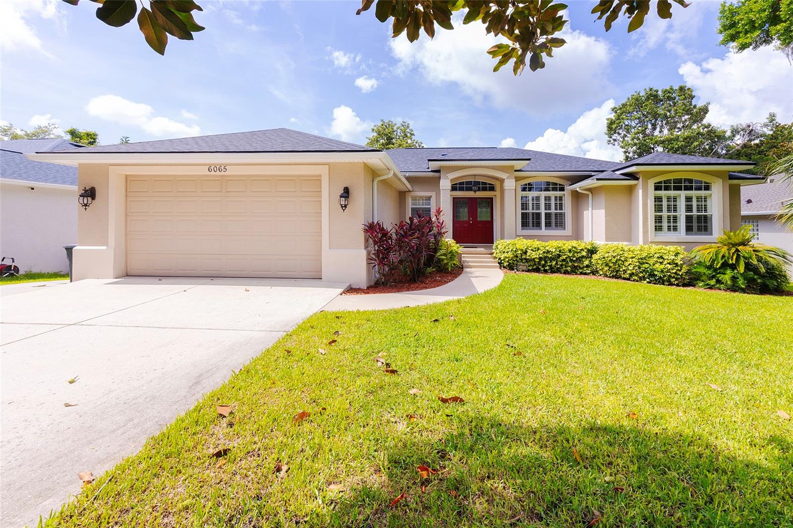 Situated in desirable Summer Trees South on a peaceful lot backing to Spruce Creek, this sprawling swimming pool home is move-in ready and waiting for a new family to enjoy. As you approach the home you will be greeted by a beautiful elevation with vibrant Florida foliage, while inside you will find generous living spaces with high ceilings and an abundance of natural light. Gleaming wood floors and convenient tile run throughout the residence, while the open kitchen boasts granite countertops, 42'' wood cabinetry, and quality stainless steel appliances. Enjoy the oversized, screened, custom swimming pool area, perfect for entertaining year-round. The large primary bedroom features a tray ceiling while in the master bathroom you will find dual vanities and a walk-in shower. The 4th bedroom on the lower level features its own bathroom and living space, and could be used as an in-law suite or private guest quarters. Growing families will love the current public school zoning that includes Sweetwater Elementary, Creekside Middle and Spruce Creek High. Don't miss out on this unique Port Orange home!