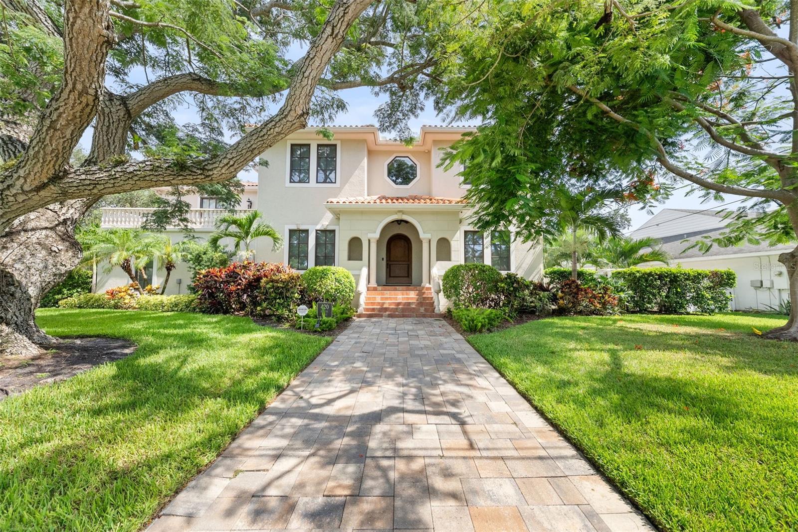 This stunning Davis Islands estate offers exceptional living on an oversized corner lot of over 1/4 acre. With six bedrooms, six full baths, and a four-car garage, this custom Spanish-style residence combines timeless architecture with modern luxury and thoughtful design throughout. A grand two-story foyer welcomes you with an elegant wrought iron staircase offering triple access—to the formal entry, the upstairs living quarters, and the rear kitchen area. The main level features a formal living room currently used as a library or home office, a formal dining room, and an expansive chef’s kitchen outfitted with rich wood cabinetry, granite countertops, a center island with breakfast bar. The kitchen opens directly to the spacious family room, creating an ideal layout for entertaining and everyday life. Top-of-the-line appliances include a Sub-Zero built-in refrigerator and freezer, dual Wolf range and oven, two Bosch dishwashers, a walk-in pantry, and a clear ice maker. The main level also offers a private guest suite with full bath, perfect for visiting family or multigenerational living. Upstairs, four additional bedrooms and three full bathrooms are complemented by a massive media and recreation room featuring a wet bar, wine bar, and kitchenette. A large terrace extends from the media room, while the luxurious primary suite offers its own expansive terrace with views of the backyard, resort-style heated saltwater pool, and play yard.
A detached guest suite includes an en-suite bath, with an additional full bath dedicated to the pool area. The electric-gated driveway accommodates three additional vehicles. There is a three bay garage and then a detached one car garage that is air-conditioned and suitable for use as a home gym or workshop. The garage also features an epoxy floor and an electric vehicle charging outlet.
This home is equipped with a natural gas generator, tankless water heater, and a laundry room outfitted with two LG washers and dryers. Outdoor living is elevated with an Alfresco kitchen, a pool with sun shelf and spill-over spa, creating a true backyard retreat.
Living on Davis Islands means enjoying a unique, amenity-rich lifestyle. This self-contained community offers a private airport, sailing club, yacht and motorboat marinas, tennis club, community pool, two parks, a dog beach, jogging and bike paths, and a small beach. Stroll or drive your golf cart to charming local businesses including boutiques, gas stations, coffee shops, ice cream shops, restaurants ranging from gourmet dining to casual favorites, and essential services like a pharmacy/post office, salons, and medical and legal offices.