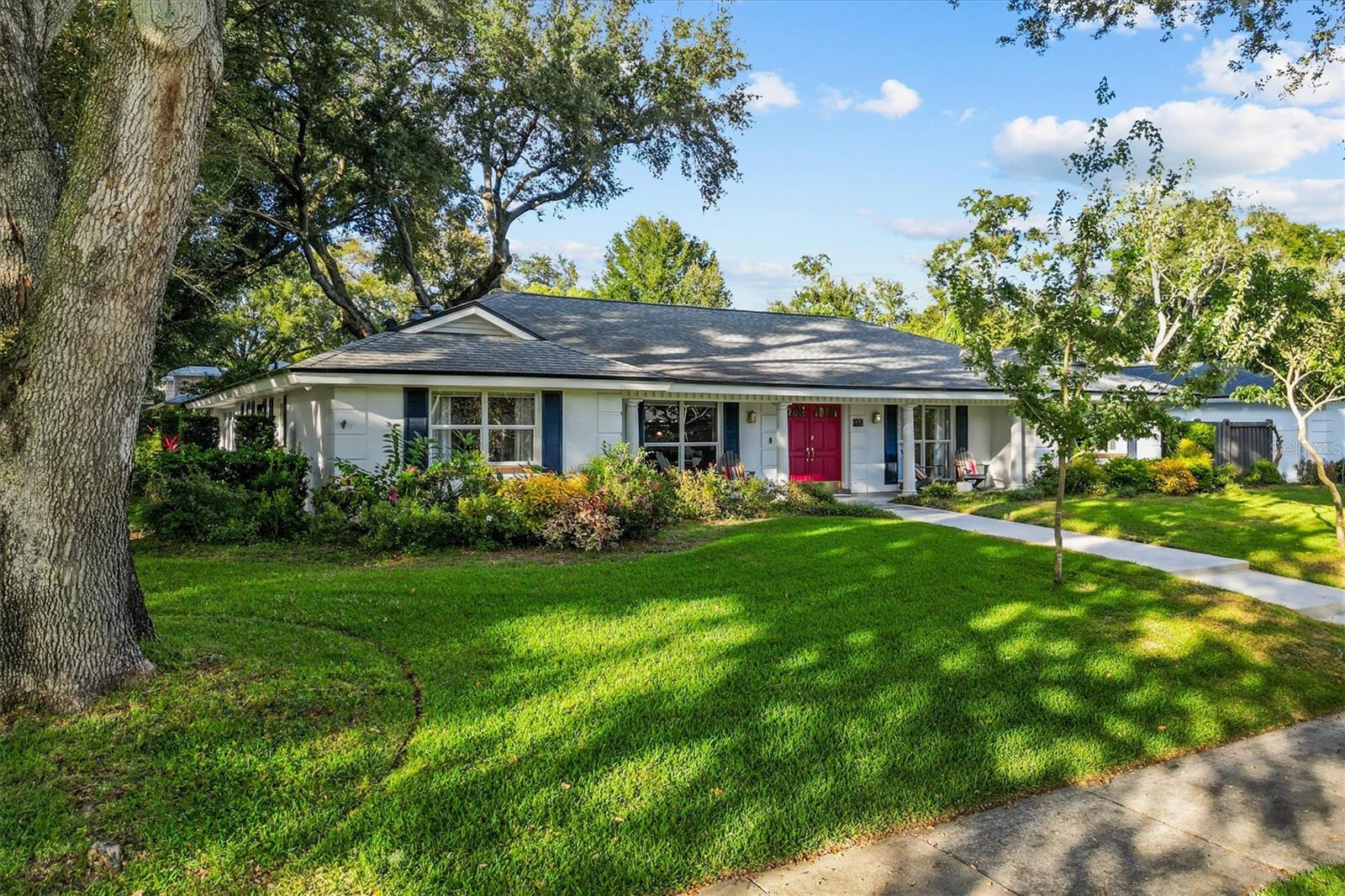 Tucked beneath the canopy of grand oaks in the iconic Southern Oaks community, this four-bedroom, two-and-a-half-bath beauty feels like a storybook home brought to life. Set on an oversized corner lot surrounded by lush, mature landscaping, it’s the kind of place where neighbors wave from porches and evening walks end under the golden sunset. From the moment you step onto the welcoming front porch—perfect for sweet tea sipping or unwinding at day’s end—you’ll feel the easy comfort that defines this home. Inside, a wide foyer opens to a sunken 1970s-style living area that now serves as a warm and inviting dining space. The kitchen is the true heart of the home—beautifully reimagined with gatherings in mind. A large cooking island with a drop-down vent anchors the space, flanked by dual pantries and a cozy coffee station with beverage refrigerators. Natural light spills in through the window overlooking the side yard, making even morning routines feel serene. Just beyond, the living area centers around a stone wood-burning fireplace, wrapped in the soft glow of Swedish White Oak flooring that flows seamlessly into the Florida Room. Here, walls of windows frame the lush backyard and pool, while custom built-ins add both charm and function—a perfect place to curl up with a book or enjoy the flowering plants. The primary suite offers a peaceful retreat with a generous walk-in closet and ensuite bath. Three additional bedrooms feature built-in closets, fresh paint, and new carpet, creating bright and welcoming spaces for family or guests. Step outside, and the magic continues. The backyard is a gardener’s dream—a living tapestry of hibiscus, amaryllis, azalea, camellia, and native flowering plants. Along the side fence, a Queen’s Wreath vine—lovingly nurtured since 2020—bursts into a cascade of blue-violet blooms each spring and early summer. Raised garden beds invite you to grow your own cut flowers or fresh veggies, and the heated saltwater pool with self-cleaning pump and separate hot tub make every day feel like a staycation. The side-entry garage keeps the front elevation picture-perfect, while offering overhead storage and direct access to a mudroom/laundry area with built-in cabinetry—just the right blend of beauty and practicality. Perfectly positioned just south of Downtown Orlando, this home offers the best of convenience and community. Zoned for Pershing K–8 and Boone High School, it’s surrounded by some of Orlando’s most sought-after amenities—shopping and dining in SoDo, the Dr. Phillips Center for the Performing Arts, Orlando City Soccer Stadium, and the Orlando Health complex are all just minutes away. And when it’s time to travel, the airport is an easy drive, making this location as connected as it is charming. Welcome home to Southern Oaks, where every day feels a little like a page from a storybook - 927 Wald Road is a home with heart—a place where traditional charm meets modern living, wrapped in the serenity of old-growth oaks and thoughtful details at every turn. Notable updates: Roof (2018) HVAC (2019) — ultra-efficient SEER 23 system, draws just 11 amps Minisplits in Florida Room & Primary Bedroom for added comfort Whole-house replumb (2022) Interior paint & new carpet (2025).