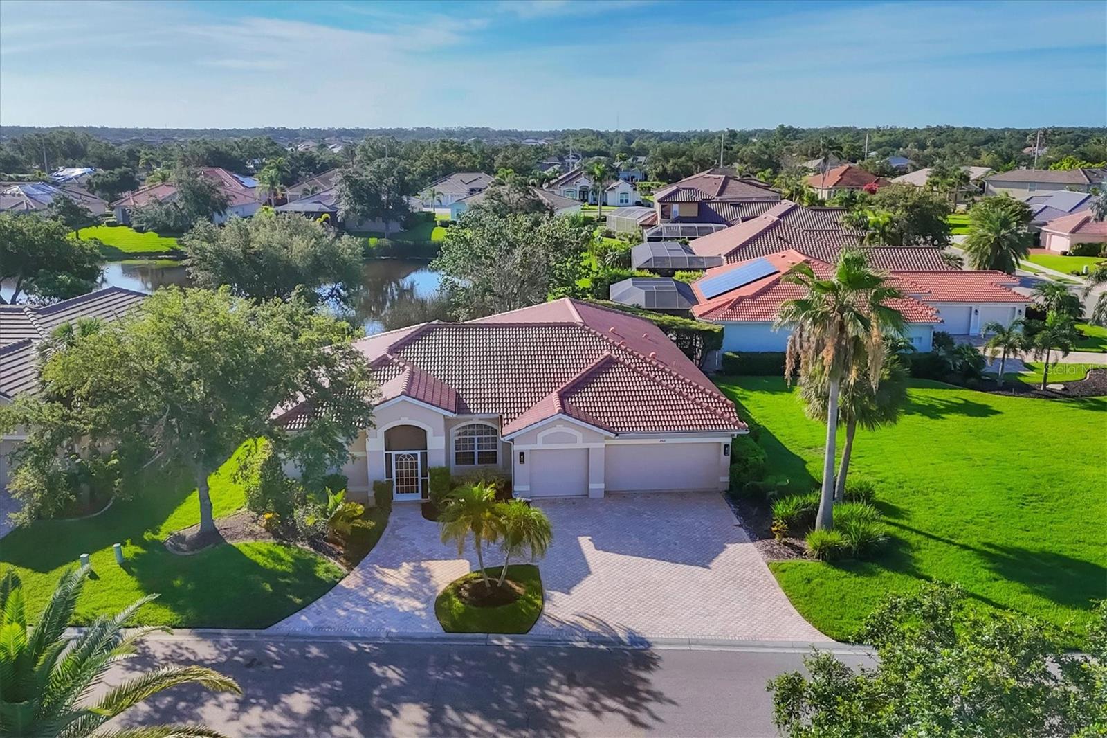 Come live the Florida lifestyle in this split plan, lakefront home with a THREE CAR GARAGE in the desirable gated community of Laurel Lakes. It’s easy living in this ONE LEVEL floor plan with HIGH CEILINGS and MULTIPLE SETS OF 8’ POCKET SLIDERS to the lanai. Tranquil water views visible from all main living areas including the primary bedroom as well as the back guest bedroom. BRAND NEW TILE ROOF INSTALLED NOV. 2024. Pull down attic access in garage for extra storage and a three car garage and paver circular driveway provide ample space for cars. HURRICANE RATED GARAGE DOORS and SHUTTERS for peace of mind and lower insurance costs. An expansive corner lot adds to the privacy and the mature landscaping adds curb appeal. Laurel Lakes is a well-maintained community offering low HOA fees, including a clubhouse with a heated pool, fitness center, pickleball/tennis courts and lots of planned social activities! Located close to everything wonderful Sarasota has to offer. Only 15-20 minutes to Downtown Sarasota, 15 min to University Town Center and Waterside, 5-10 min to hiking in beautiful Celery Fields and Rothenbach park and 25-30 minutes to Lido or Siesta Key beach! Come check it out and make this your new place to call home!