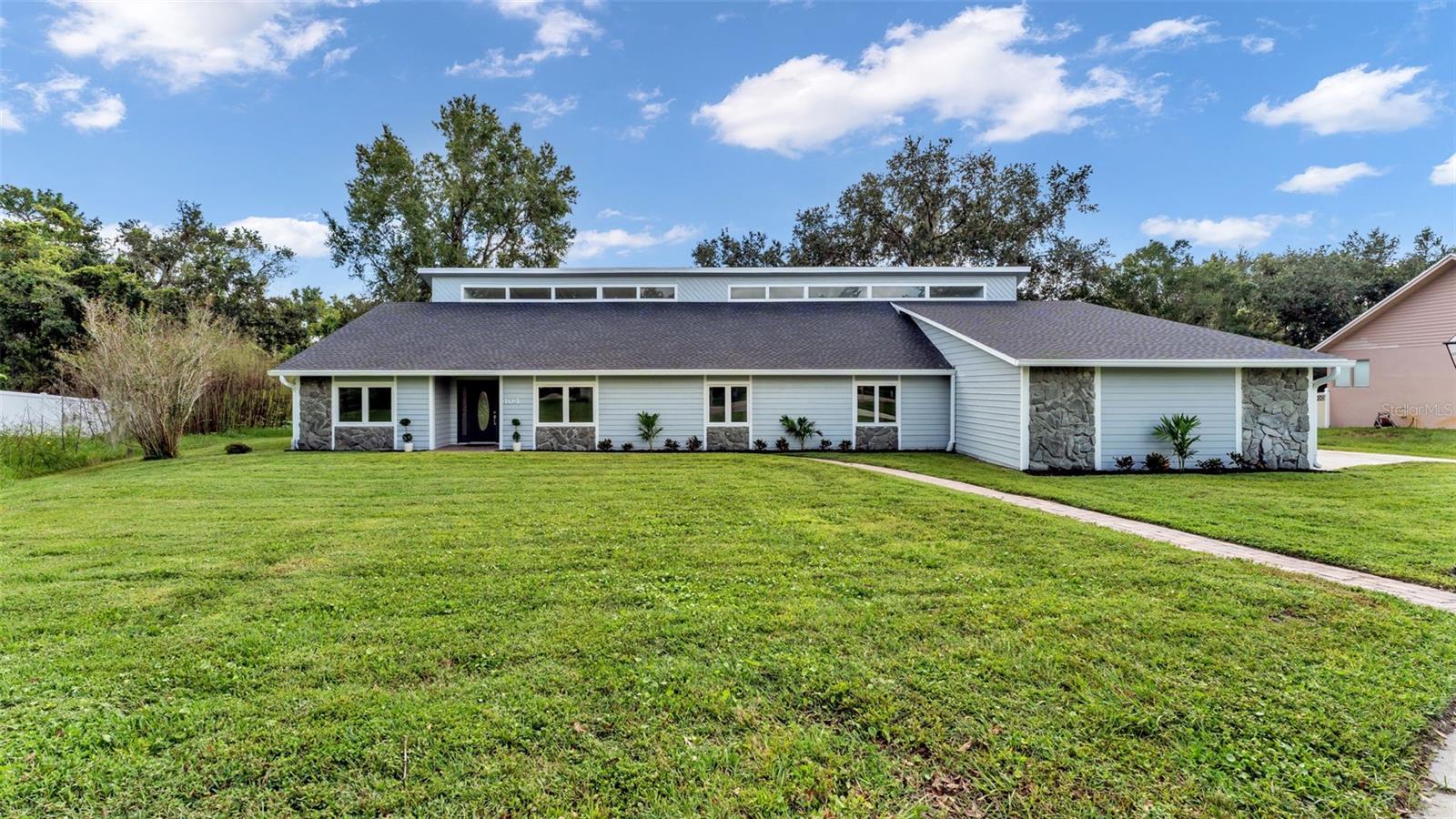 Welcome to 404 Tomahawk Trail in the desirable Indian Hills community — a stunning and fully remodeled 5-bedroom, 3-bathroom home offering 2,908 square feet of elegant living space. Designed for both comfort and versatility, this home features two spacious living rooms, an office, and a gorgeous sunroom filled with natural light from cathedral ceilings and upper windows that create a bright, airy ambiance. Both common areas include cozy fireplaces, while the modern kitchen showcases stainless steel appliances and stylish finishes. The in-law or guest suite on the left side of the home enjoys its own private living space — ideal for extended family or visitors. On the right side, you’ll find additional bedrooms along with a second primary suite featuring a walk-in closet, a large walk-in shower, and an updated cedar sauna for a true spa-like retreat. Recent updates include a brand-new roof, fresh interior and exterior paint, and new luxury vinyl plank flooring throughout. Situated on a nearly half-acre cul-de-sac lot, this property offers a large driveway, three-car garage, and an expansive screened lanai spanning the entire back of the home, complete with ceiling fans and views of the peaceful backyard — perfect for relaxing or entertaining in style.