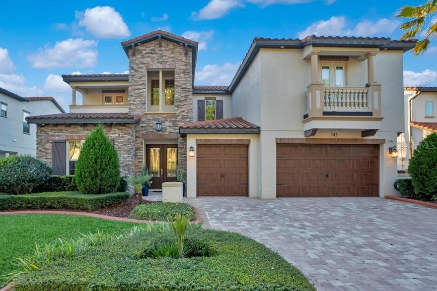 There is a specific kind of silence that exists only within the gated sanctuary of Canopy Oaks. It is the sound of ancient oak leaves stirring in a gentle breeze and the distant, rhythmic splash of a stone fountain. Here, the recipient of the Parade of Homes Grand Award stands as a magnificent testament to what happens when timeless Italian architecture is reimagined for a modern lifestyle. This is not merely a residence. It is a legacy of vertical liberation, a home that breathes with you, scales with your ambitions, and cradles your quietest moments in an embrace of stone and iron. Your journey begins at the threshold of 8-foot, solid double-entry doors. As they swing open, the frantic pace of Central Florida fades, replaced by a two-story foyer that commands immediate respect. A hand forged iron staircase sweeps upward in a graceful arc, mirrored by the delicate charm of a Juliette balcony that suggests a life lived with a touch of Mediterranean flair. Every inch of this grand entrance is a curated experience, designed to transition you into a realm of meticulously crafted prestige where every shadow and light well has been considered. For those who view cooking as a performance art, the professional-grade kitchen is your stage. High-end Kitchen Aid appliances and a natural gas cooktop meet the warmth of artisanal design. The 42-inch upper cabinetry and a hidden walk-in pantry ensure the visual continuity remains unbroken. At the center sits a massive prep island with integrated beverage refrigeration, designed specifically for the art of hosting. Here, the boundary between chef and guest is delightfully blurred. Nearby, the home reveals its most enchanting secret, the drop-down wine cellar. Behind a hand-forged iron gate lies a space that transports you directly to a cobblestone alleyway in Tuscany. With label-forward shelving casting a museum-quality glow and a quaint bistro table within, it evokes the feeling of a private corner in a centuries-old Italian eatery. It is the ultimate setting for an evening pour, a space where time slows down and the modern world feels a thousand miles away. The first-floor owner’s suite is a masterclass in personal seclusion. By design, this space serves as a dedicated haven of quietude, featuring soaring tray ceilings and an atmosphere of total stillness. The spa-inspired bath, featuring a frameless glass walk-through shower and a free-standing soaking tub, offers a daily ritual of total restoration. As you ascend, the lifestyle shifts toward entertainment. The dedicated theater room stands ready for premiere nights, offering a dark, immersive escape. Adjacent, the versatile gathering room opens onto a private balcony overlooking the shimmering resort-style pool and the vast, permanent conservation area. With no rear neighbors, your view is an unbroken tapestry of natural beauty. The outdoor living area features a resort-style pool and spa framed by water/fire bowls and a rainfall pergola. With a full summer kitchen and a backyard that merges into conservation, your privacy is absolute. Enjoy the nightly glow of nearby fireworks from your peaceful terrace, surrounded by the scent of night-blooming jasmine. Strategically along the medical corridor, you are minutes from AdventHealth, Orlando Health and the soul of Winter Garden. Backed by a whole-house natural gas generator and water purification, this home offers security and beauty. Welcome home. Check out the video tour!