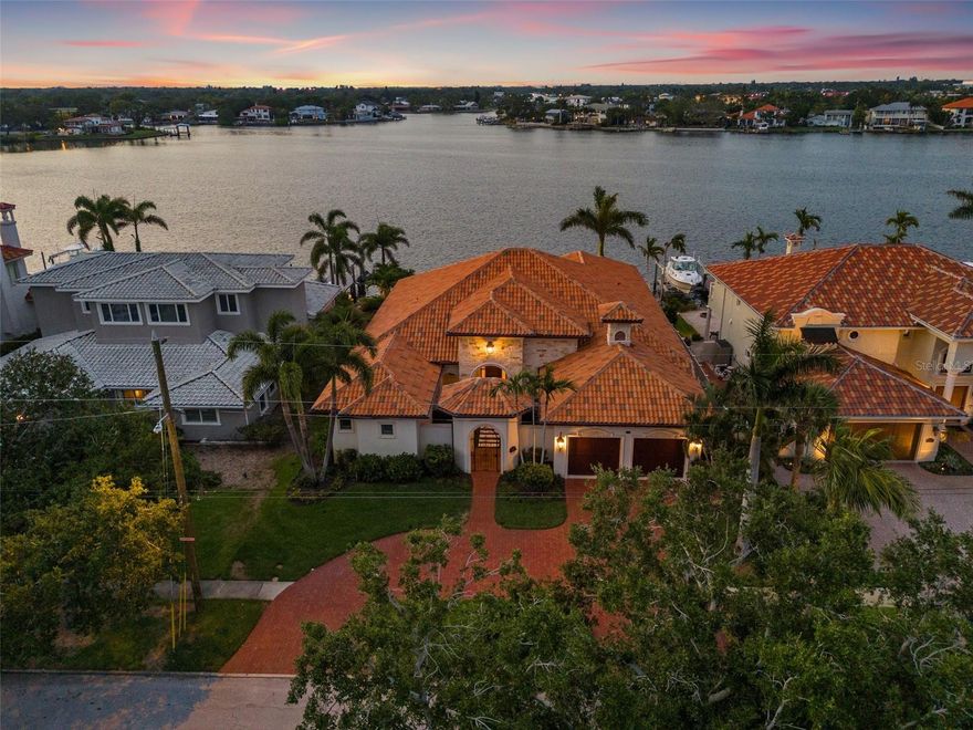 Experience coastal elegance and luxury living at its finest at 301 Bayview Drive NE, nestled on the shores of Smacks Bayou in the exclusive  Snell Isle neighborhood of St. Petersburg. Elevation is 9.8 and sustained NO WATER INTRUSION in recent storms. Built by Andrew Vecchio in 2015, this exceptional waterfront residence offers superior craftsmanship, timeless finishes, and a flexible floor plan designed for modern Florida living. Enjoy sweeping water views the moment you step inside. Soaring 10–12 ft ceilings throughout the home create an airy, open atmosphere, enhanced by gorgeous engineered hardwood flooring, custom designer lighting, and upscale finishes. The main living space is anchored by a stunning gas fireplace and filled with natural light from oversized windows and glass doors. The chef’s kitchen is a showstopper—featuring top-of-the-line Thermador appliances, a gas cooktop, pot filler, wine refrigerator, pantry, stone countertops, and an oversized island with bar seating—perfect for gathering and entertaining.
Enjoy your private waterfront oasis with a heated saltwater pool, spa, covered lanai, outdoor kitchen, and private dock. Whether you're hosting sunset dinners or launching paddleboards from your backyard, this home was built for the Florida lifestyle.
The private primary suite is a serene retreat offering panoramic water views, dual walk-in closets, and a spa-inspired en suite bath with dual vanities, a freestanding Jacuzzi soaking tub, and a glass-enclosed walk-in shower. Each guest bedroom includes its own en suite bath, providing comfort and privacy for family and guests. A unique highlight of this home is the separate casita/in-law suite—attached yet completely private with its own entrance, walk-in closet, and full bath. It’s ideal for multi-generational living, a dedicated home office, home gym, or studio. Additional features include a spacious laundry room, 3-car garage with high ceilings for extra storage or lift installation, and a circular brick driveway that enhances curb appeal. Located minutes from vibrant downtown St. Pete, yet tucked away in a peaceful enclave, 301 Bayview Drive offers the best of both worlds—quiet luxury living with world-class dining, culture, and shopping just moments away.